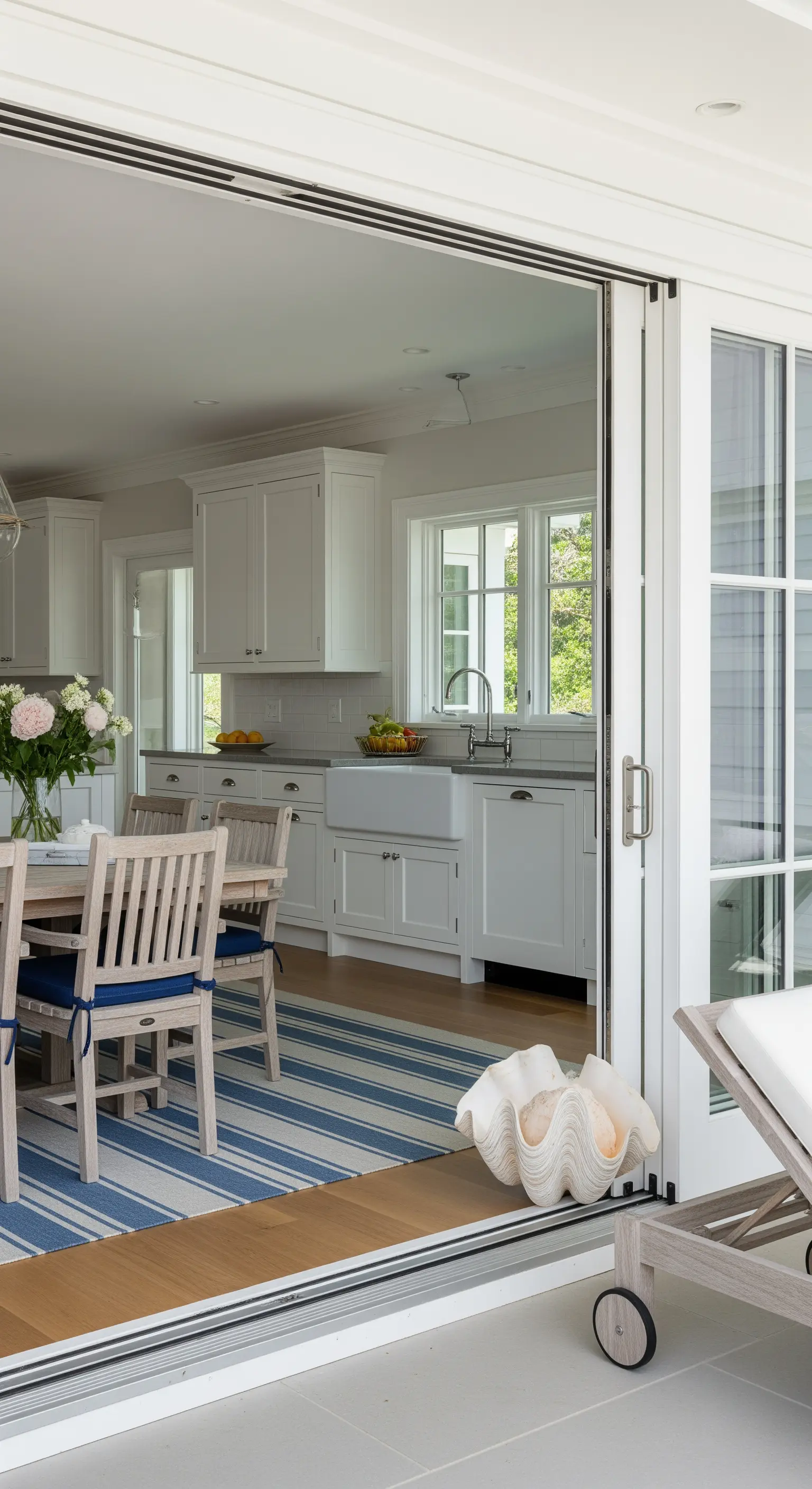 Ampia porta scorrevole a vetri che collega la cucina a un patio esterno.