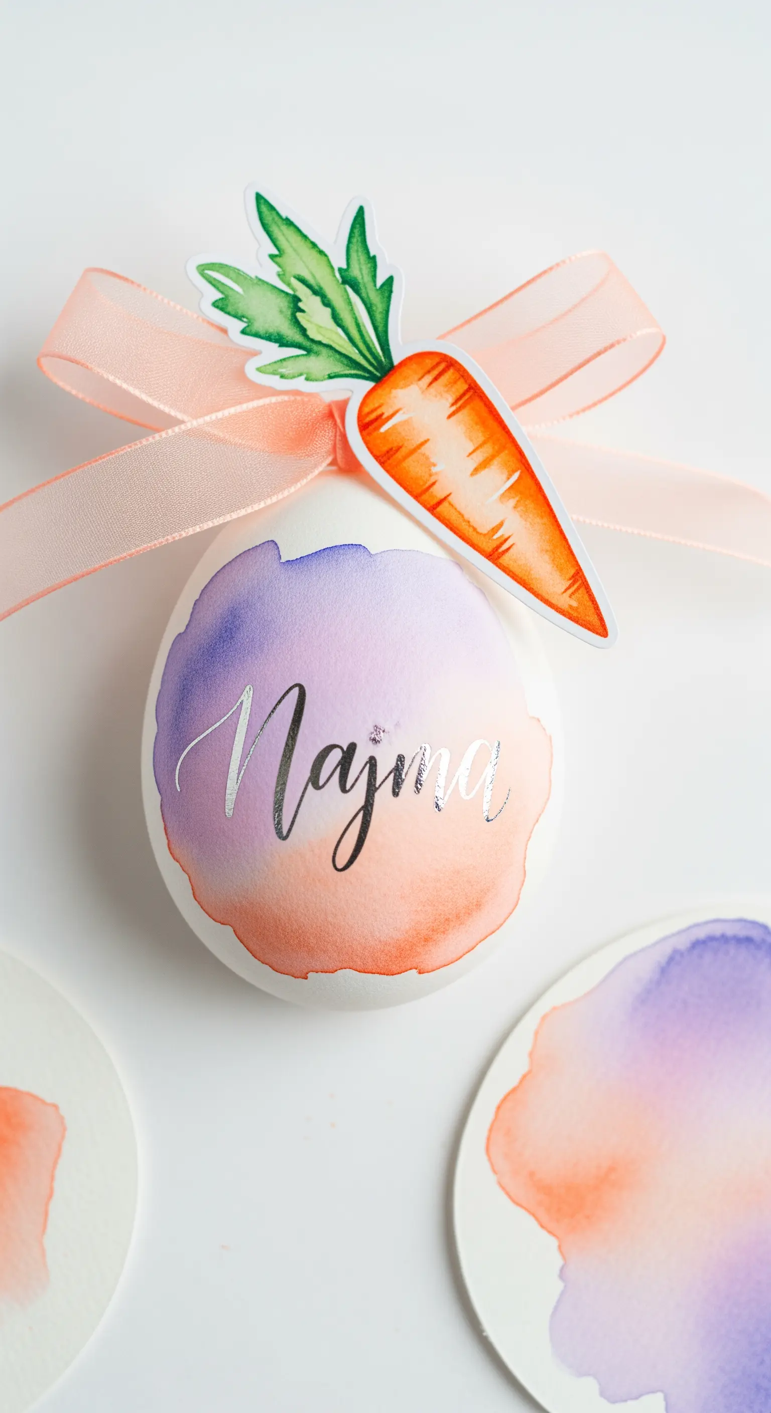 Segnaposto con uovo decorato ad acquerello, nome in calligrafia e carota di carta.