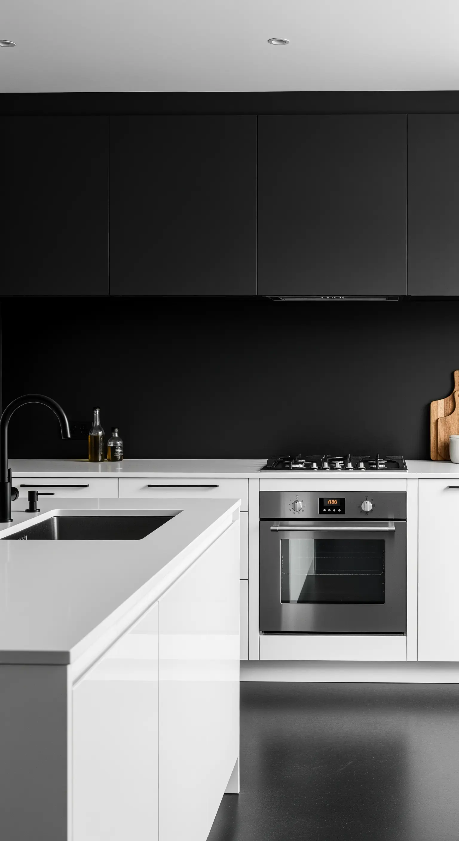 Cucina con base bianca, pensili neri opachi e forno in acciaio inox.
