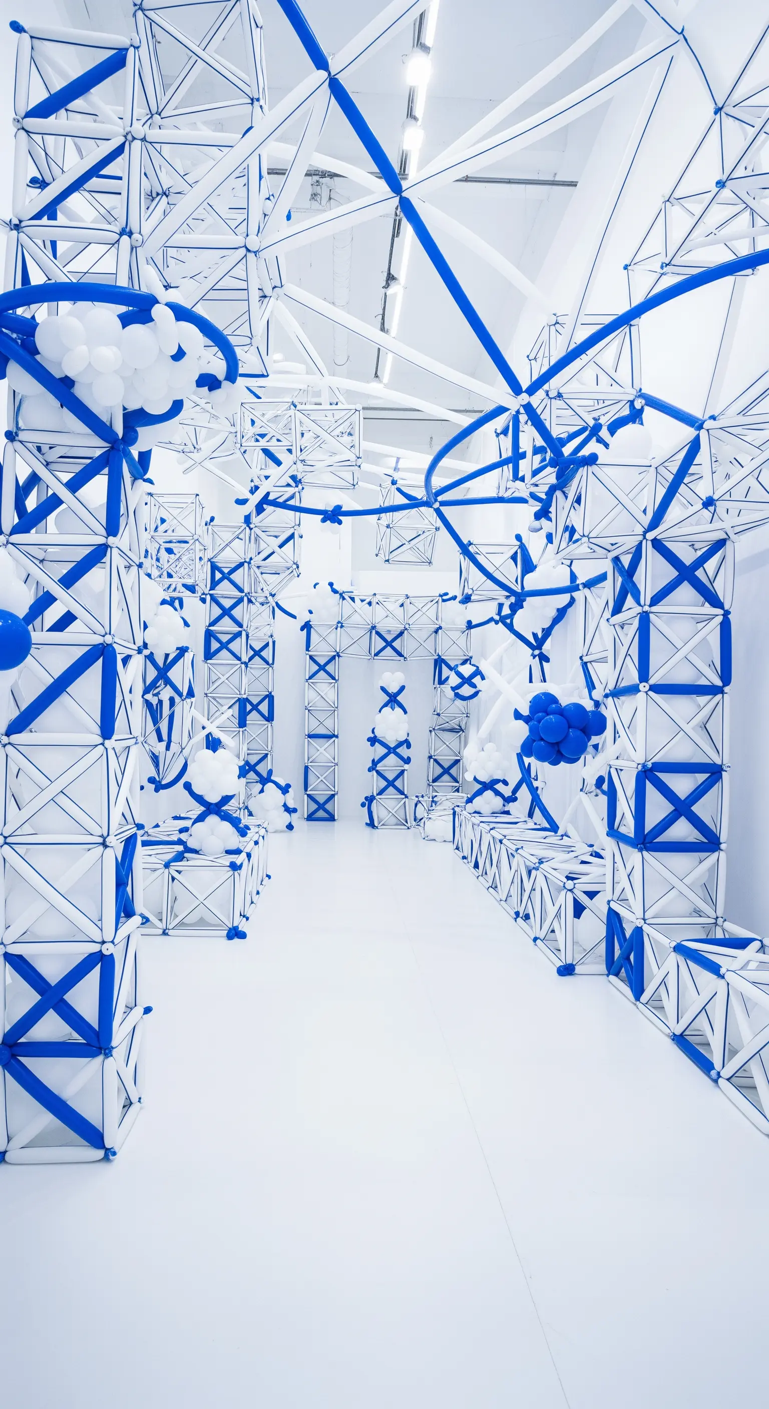 Installazione architettonica realizzata con una complessa struttura di palloncini bianchi e blu.