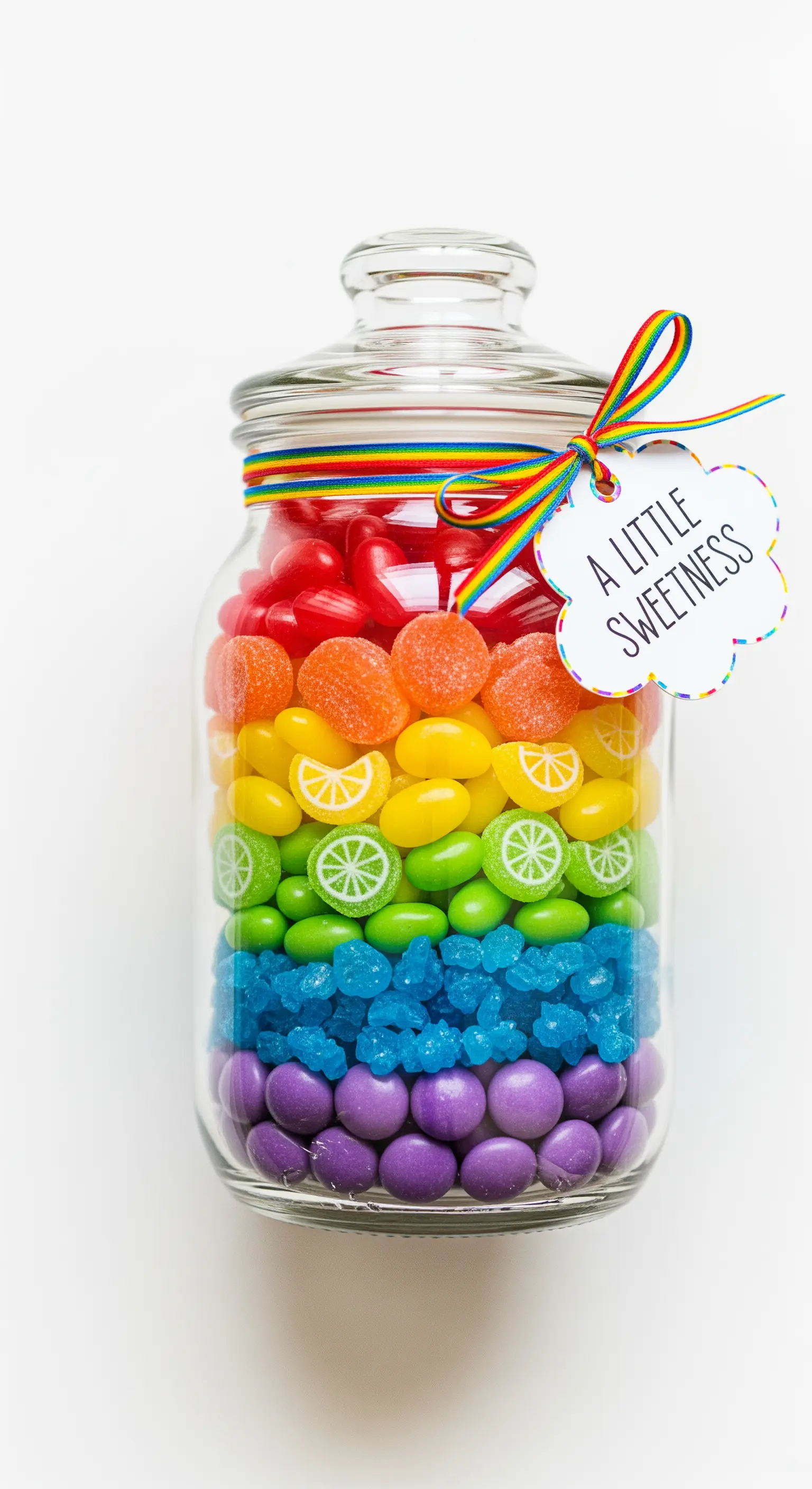 Barattolo di vetro con strati di caramelle colorate a formare un arcobaleno.