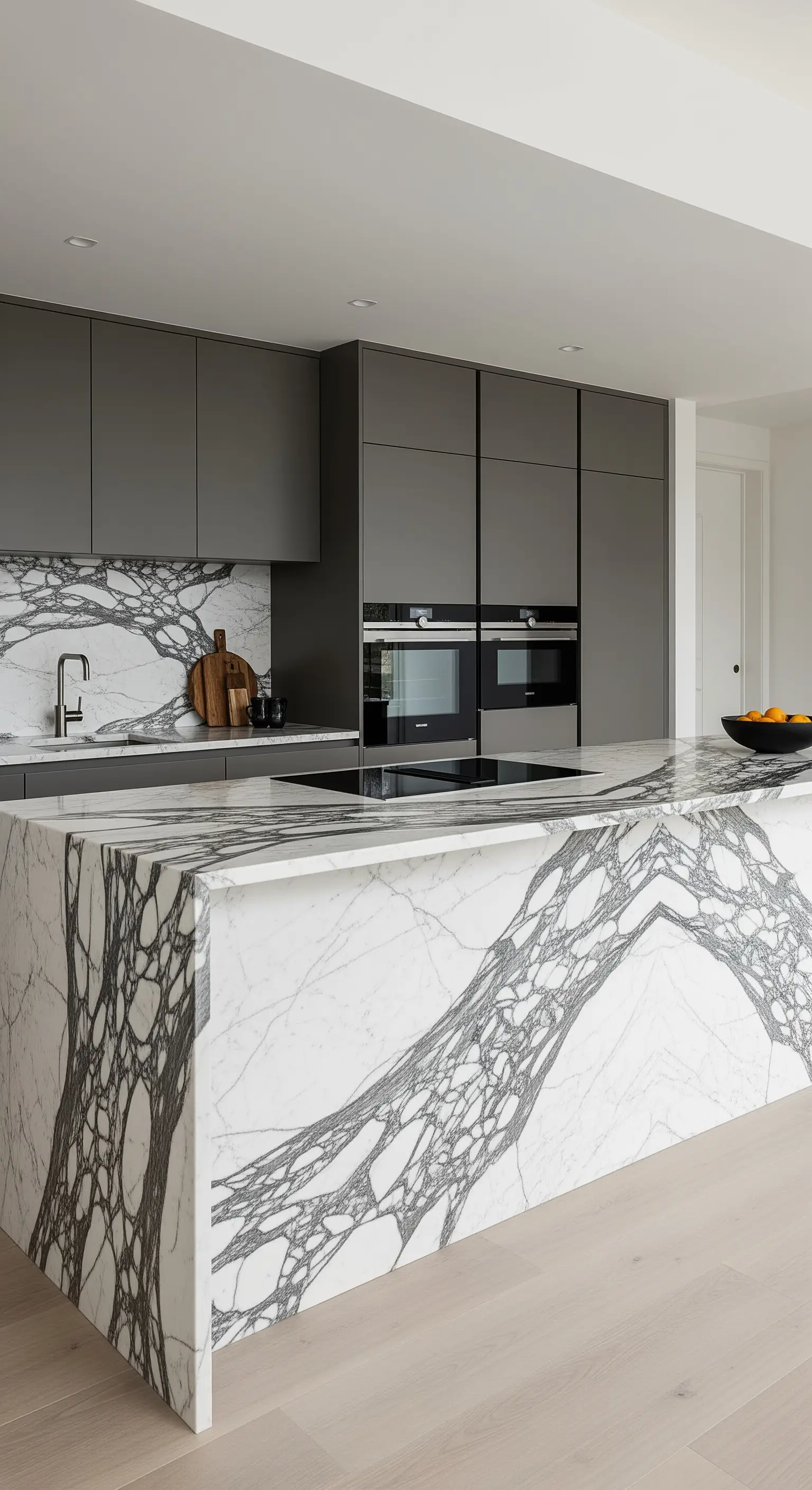 Isola e paraschizzi della cucina realizzati con marmo dalle venature nere molto evidenti.