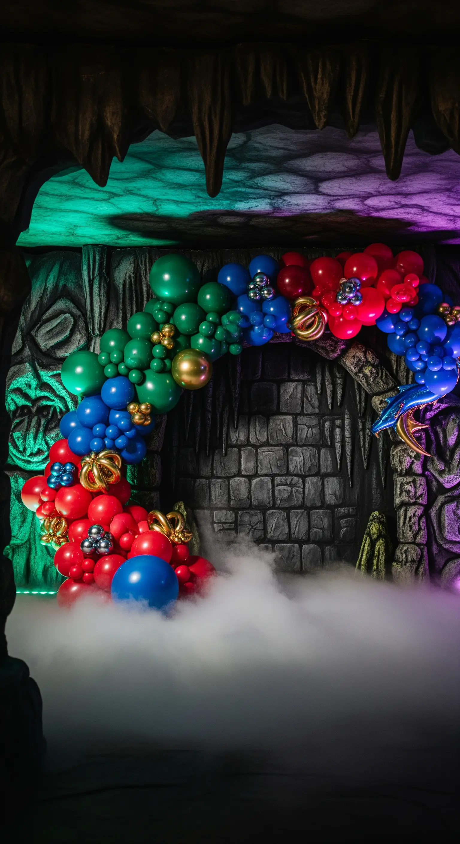 Allestimento fantasy in una grotta con arco di palloncini colorati e macchina del fumo.