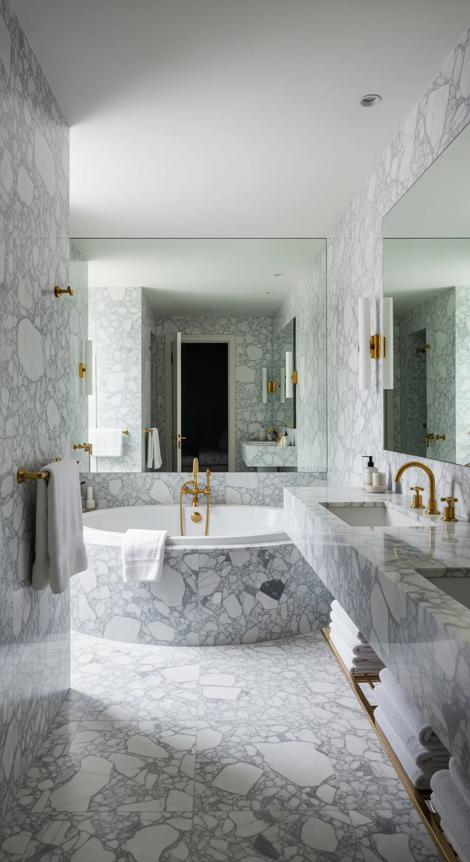 Bagno completamente rivestito in marmo grigio venato, inclusi lavabo e vasca.