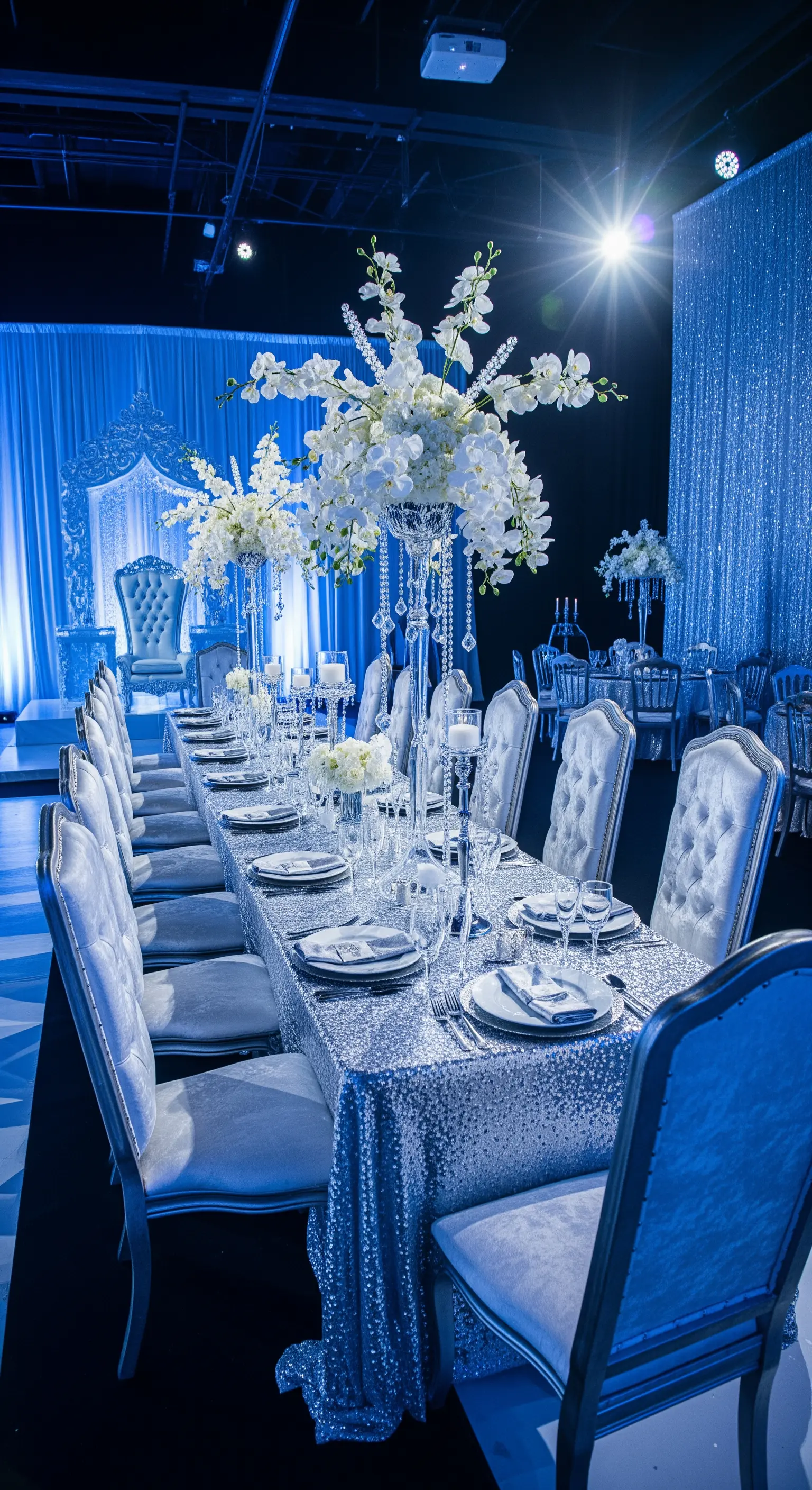 Tavola da ricevimento con tovaglia di paillettes argento e sedie in velluto.