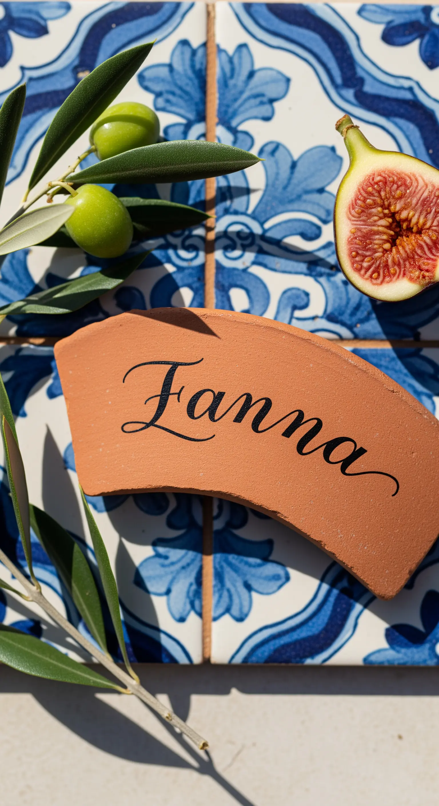Frammento di terracotta con nome calligrafato, accanto a olive e un fico.