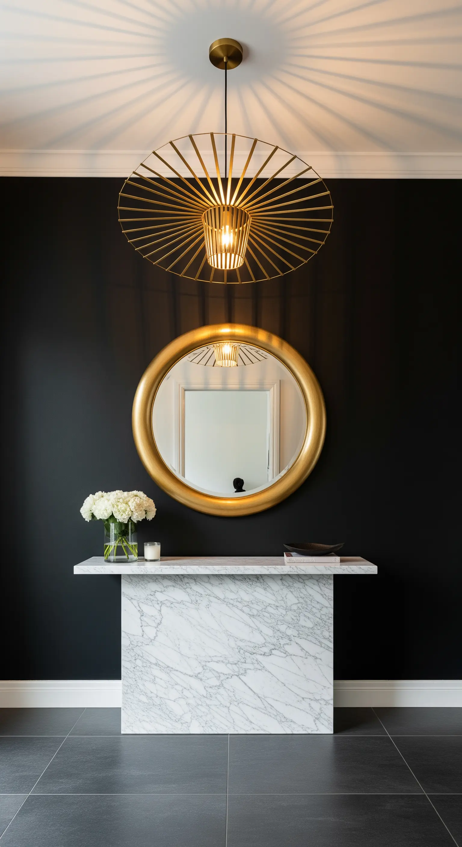 Parete nera con consolle in marmo bianco, specchio e lampada dorati.