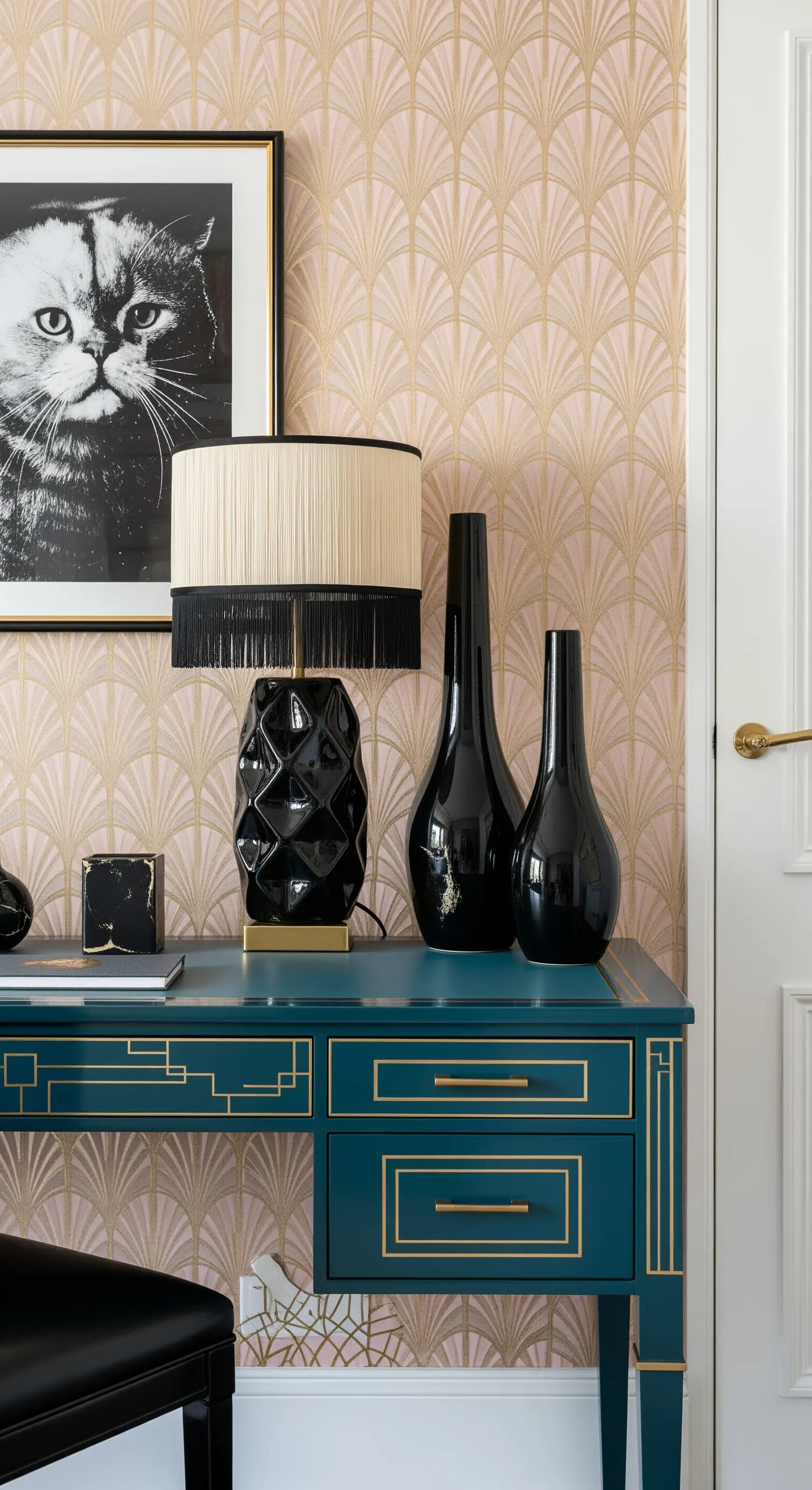 Scrivania ottanio con dettagli dorati, vasi neri e carta da parati Art Déco rosa e oro.