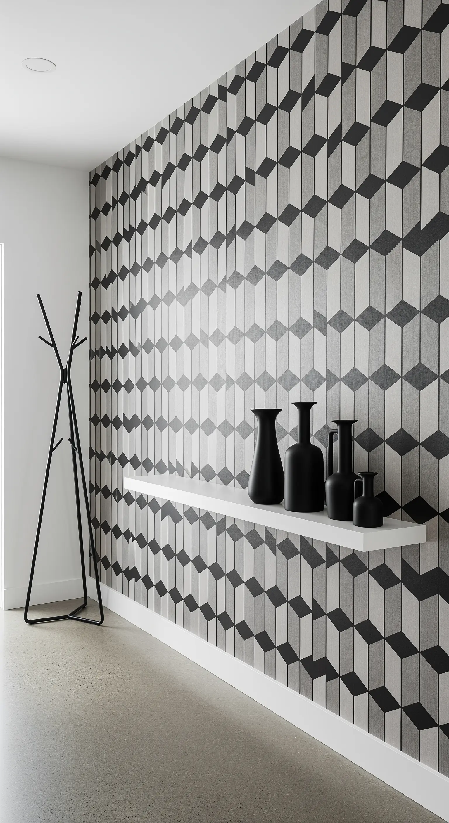 Parete d'accento con carta da parati a motivi geometrici 3D e una mensola bianca con vasi neri.