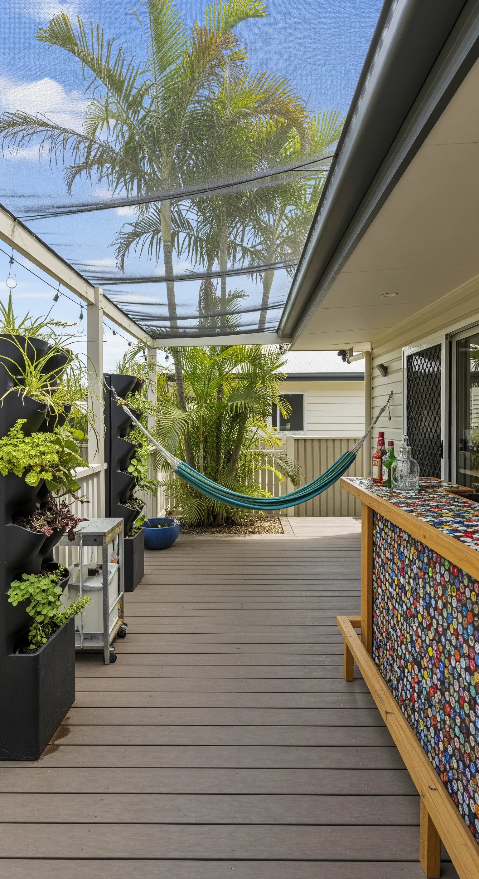 Portico con bar rivestito da un mosaico di tappi di bottiglia, rete ombreggiante e fioriere verticali