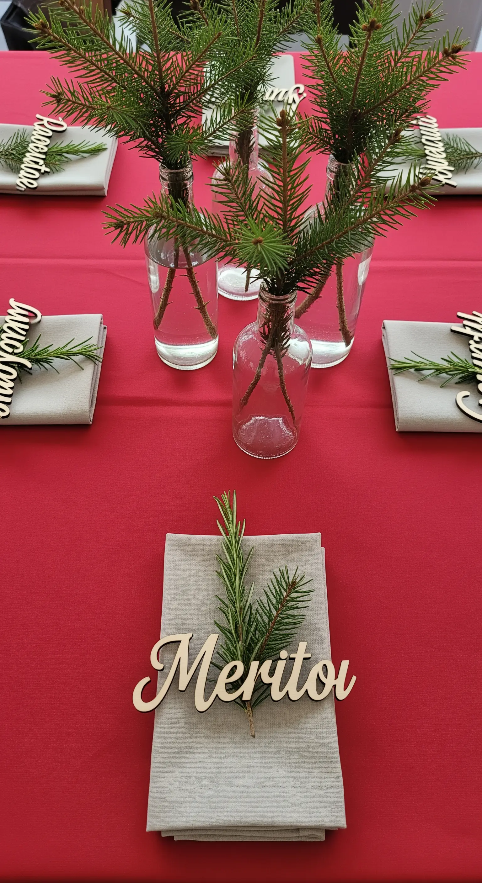 Segnaposto con nome in legno e tovagliolo decorato con rosmarino e pino.