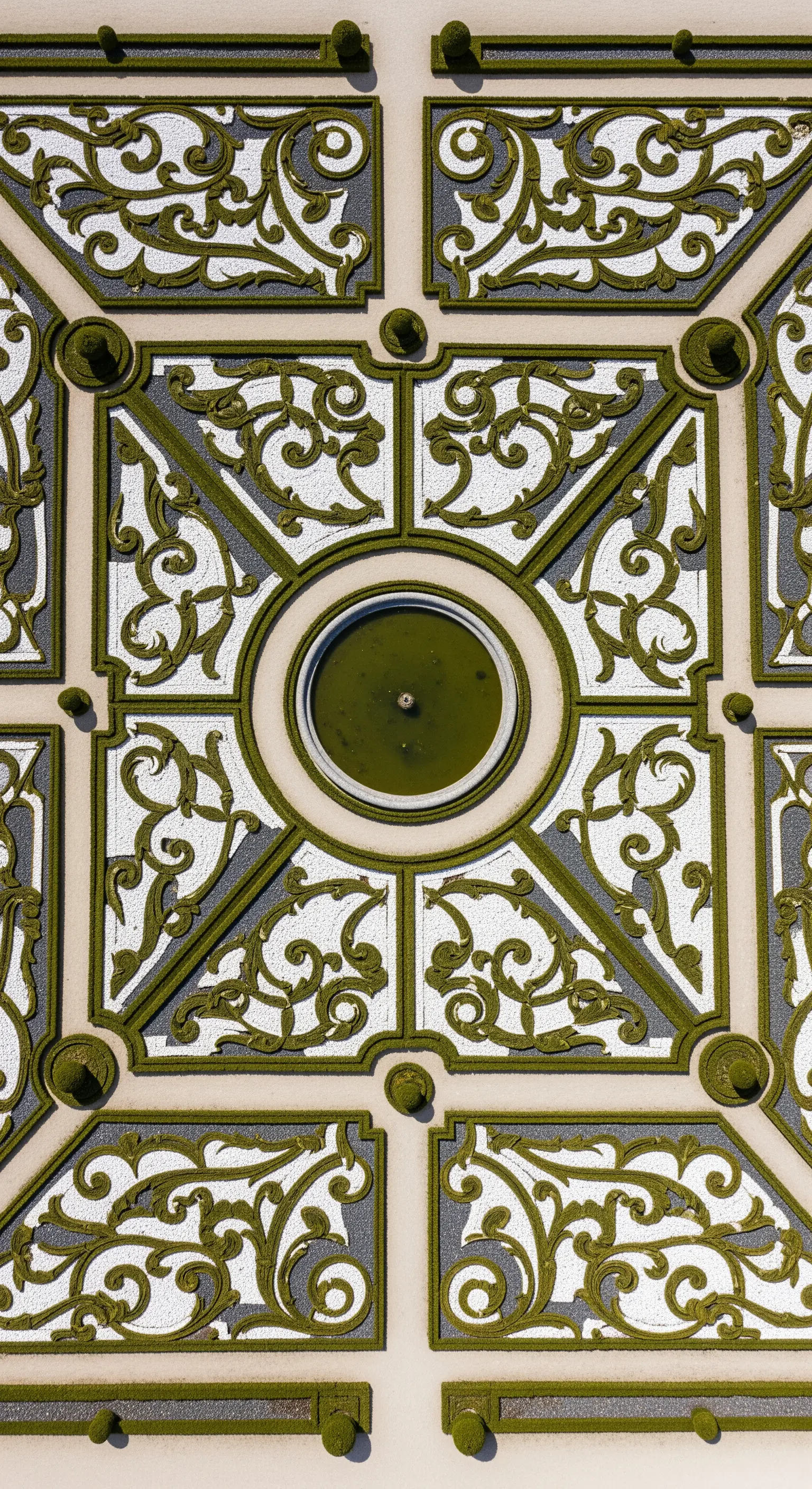 Vista aerea di un giardino con siepi di bosso che creano un disegno barocco su fondo di ghiaia.