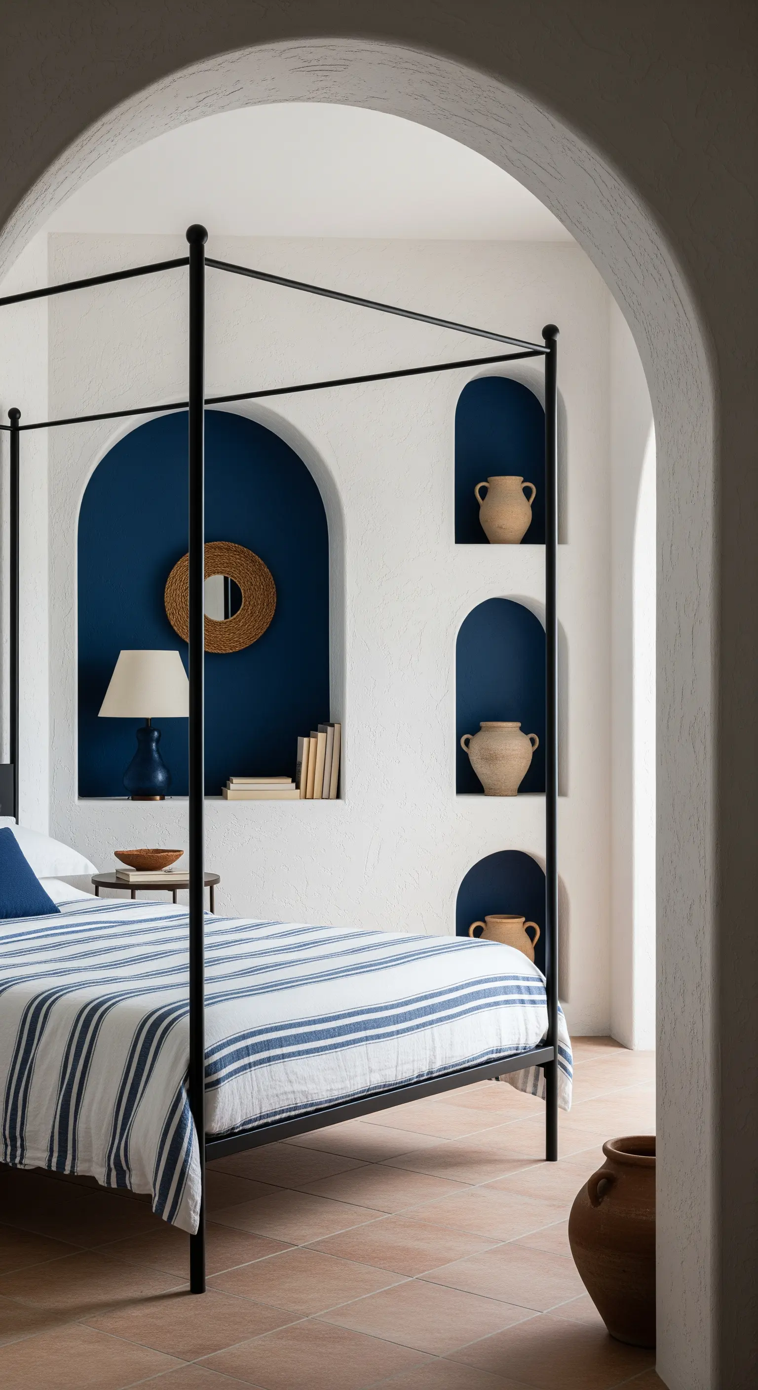 Letto a baldacchino nero in una camera da letto in stile mediterraneo con nicchie ad arco blu.