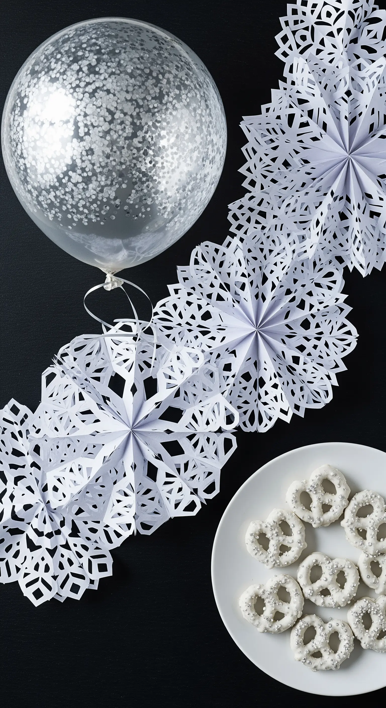 Decorazioni invernali con ghirlanda di fiocchi di neve di carta e palloncino argentato.