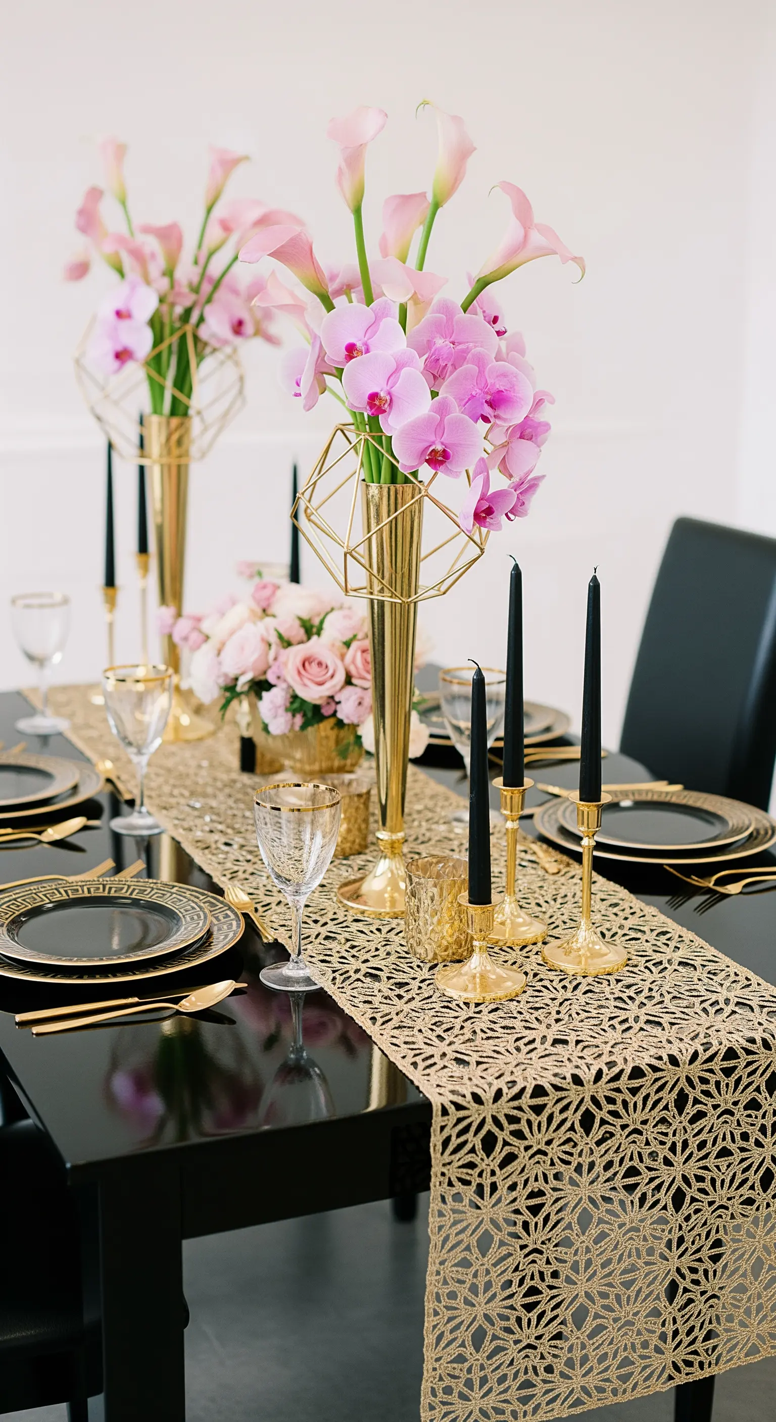 Tavola moderna nera e oro con runner geometrico, vasi scultorei e orchidee rosa.