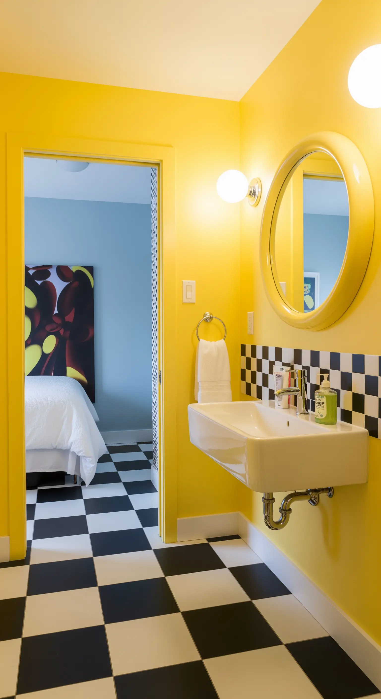 Bagno con pareti gialle, pavimento a scacchi e specchio rotondo giallo.