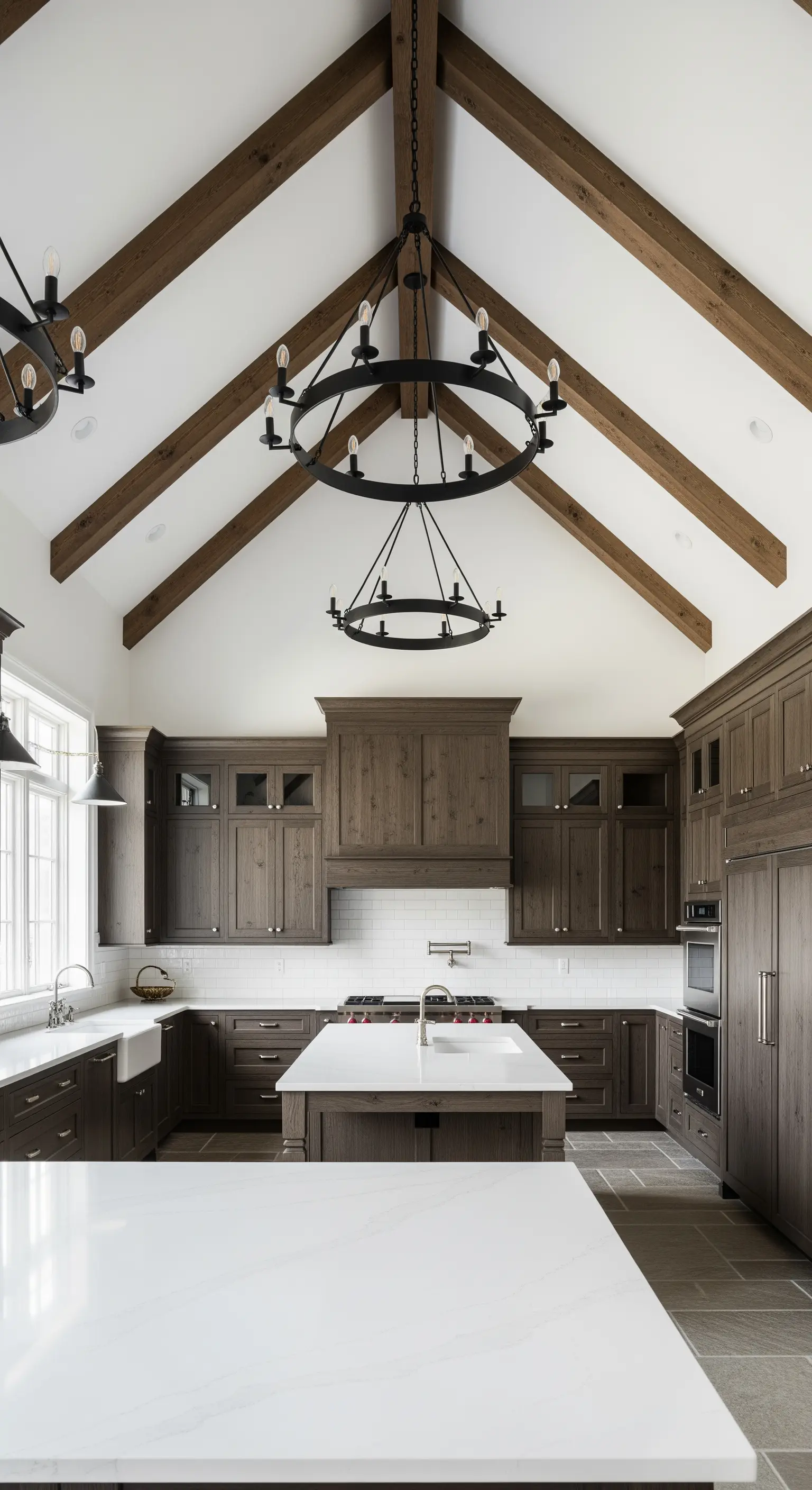 Grande cucina con soffitto a cattedrale, travi in legno a vista e mobili scuri.