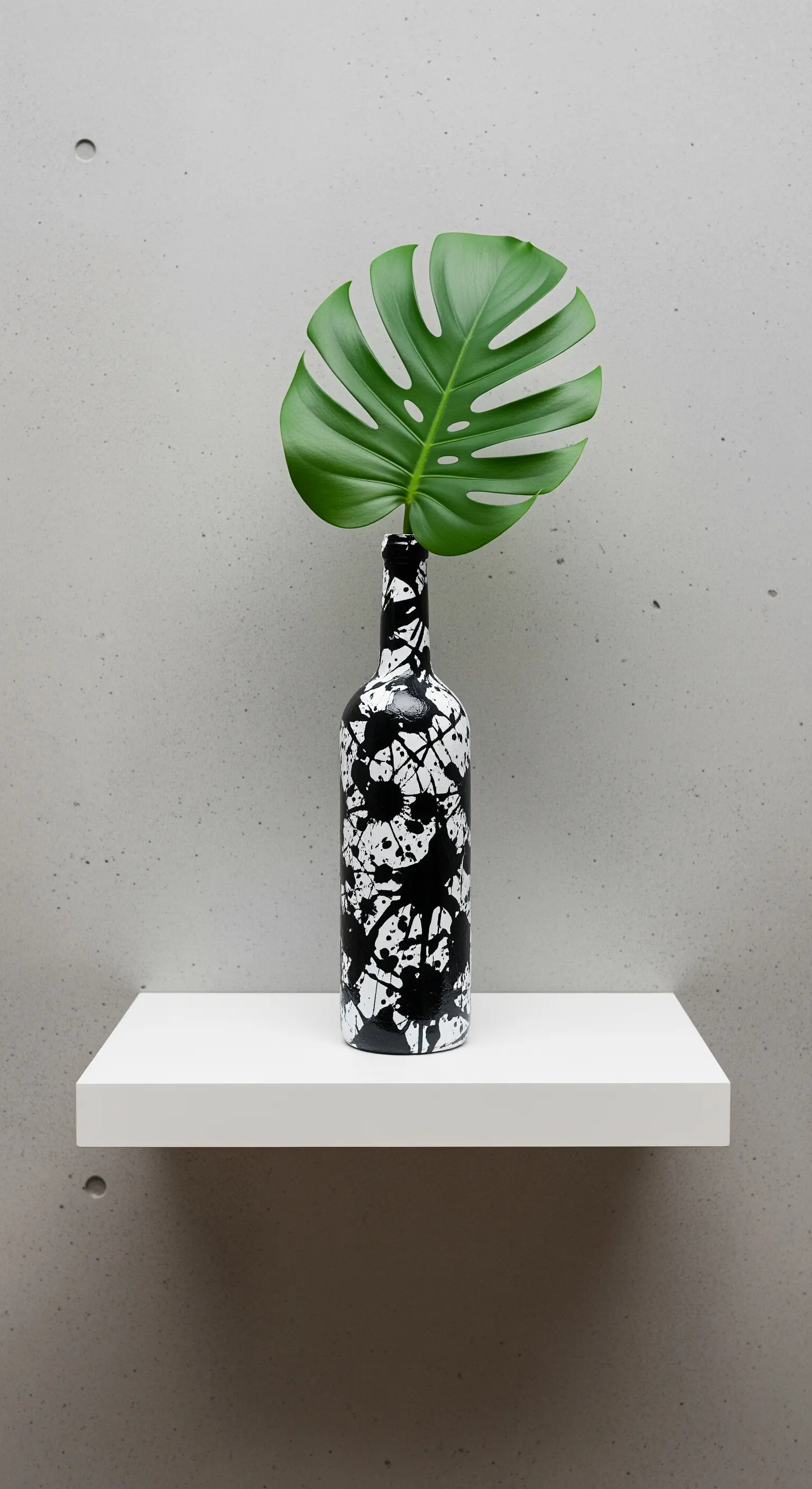 Vaso bianco realizzato con una bottiglia, decorato con schizzi di vernice nera.