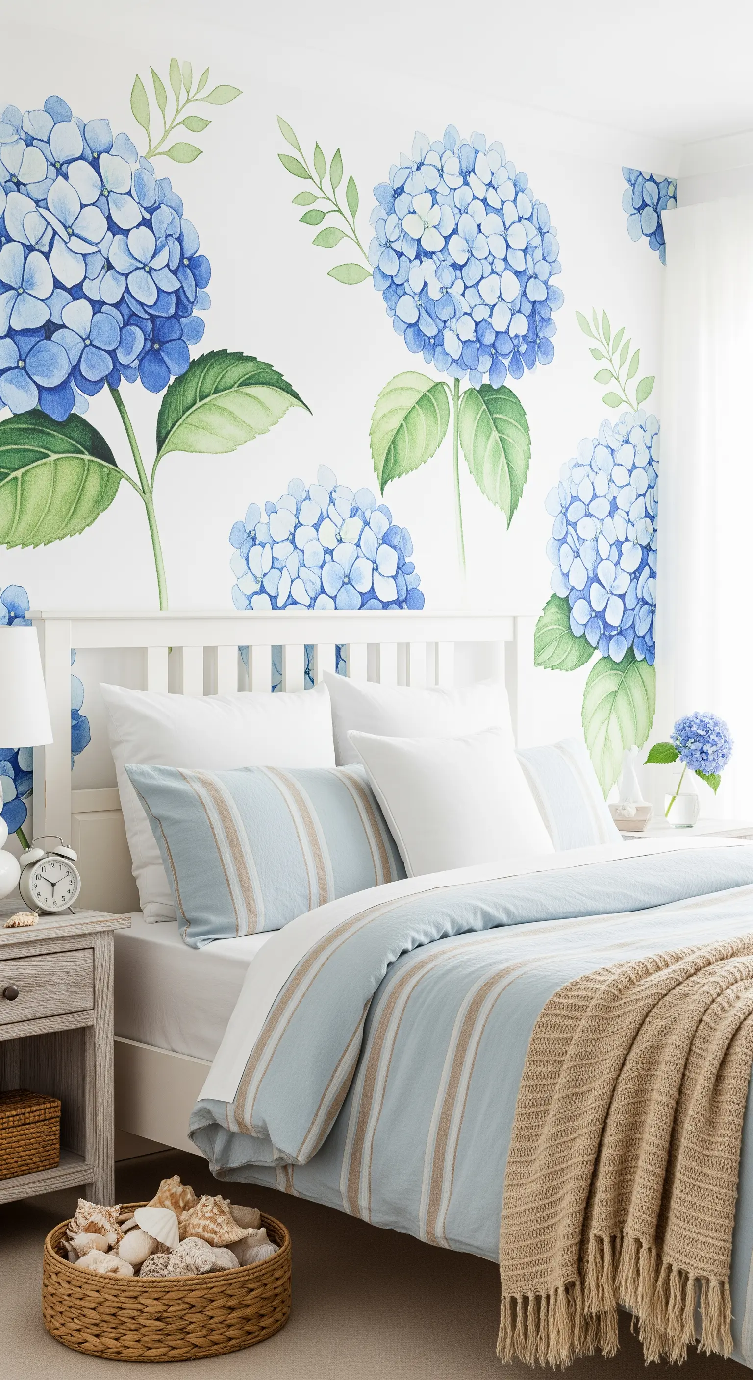 Carta da parati con ortensie blu in una camera da letto in stile costiero con mobili bianchi.