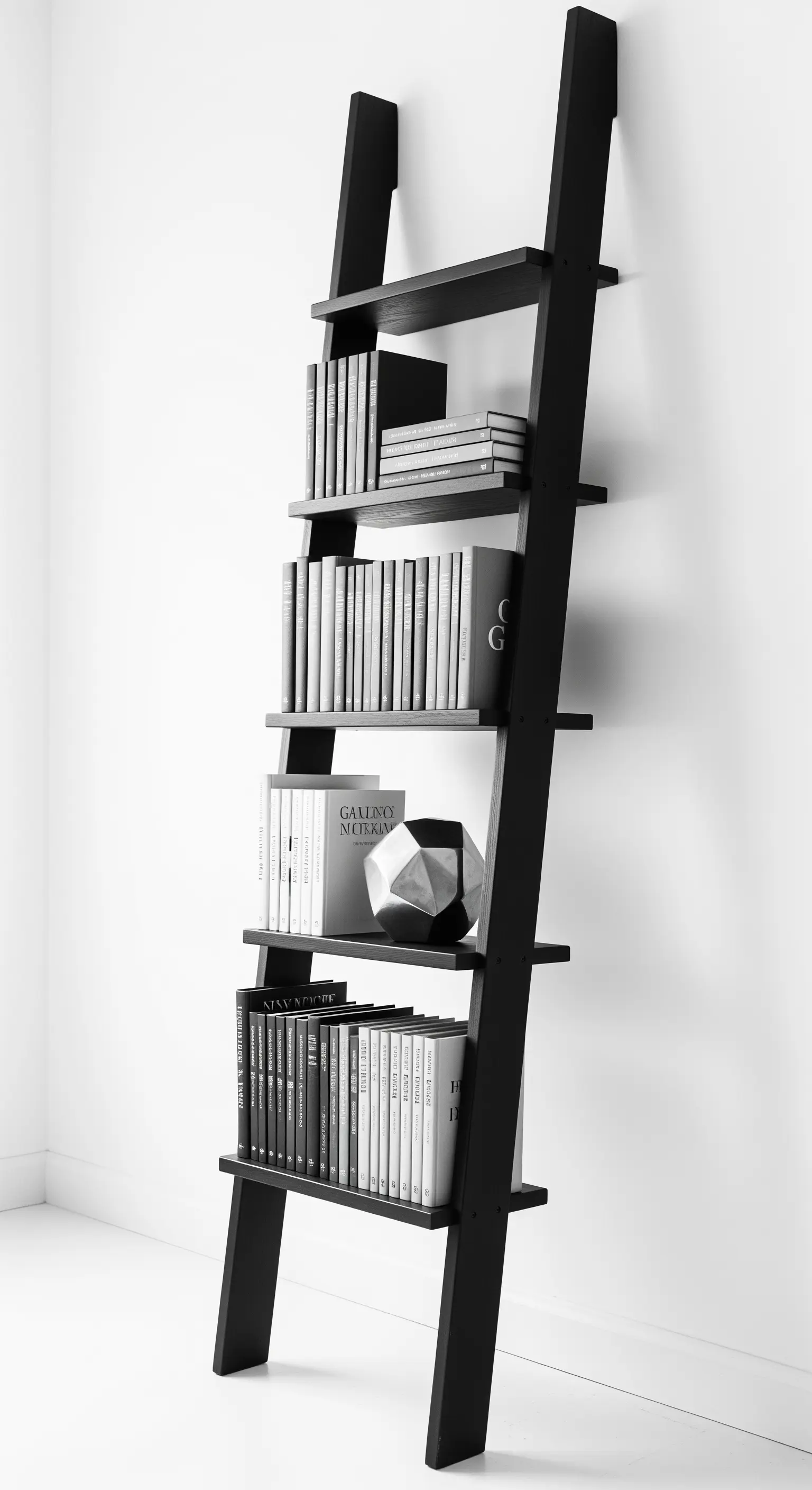 Libreria a scala nera appoggiata a una parete bianca con libri monocromatici.