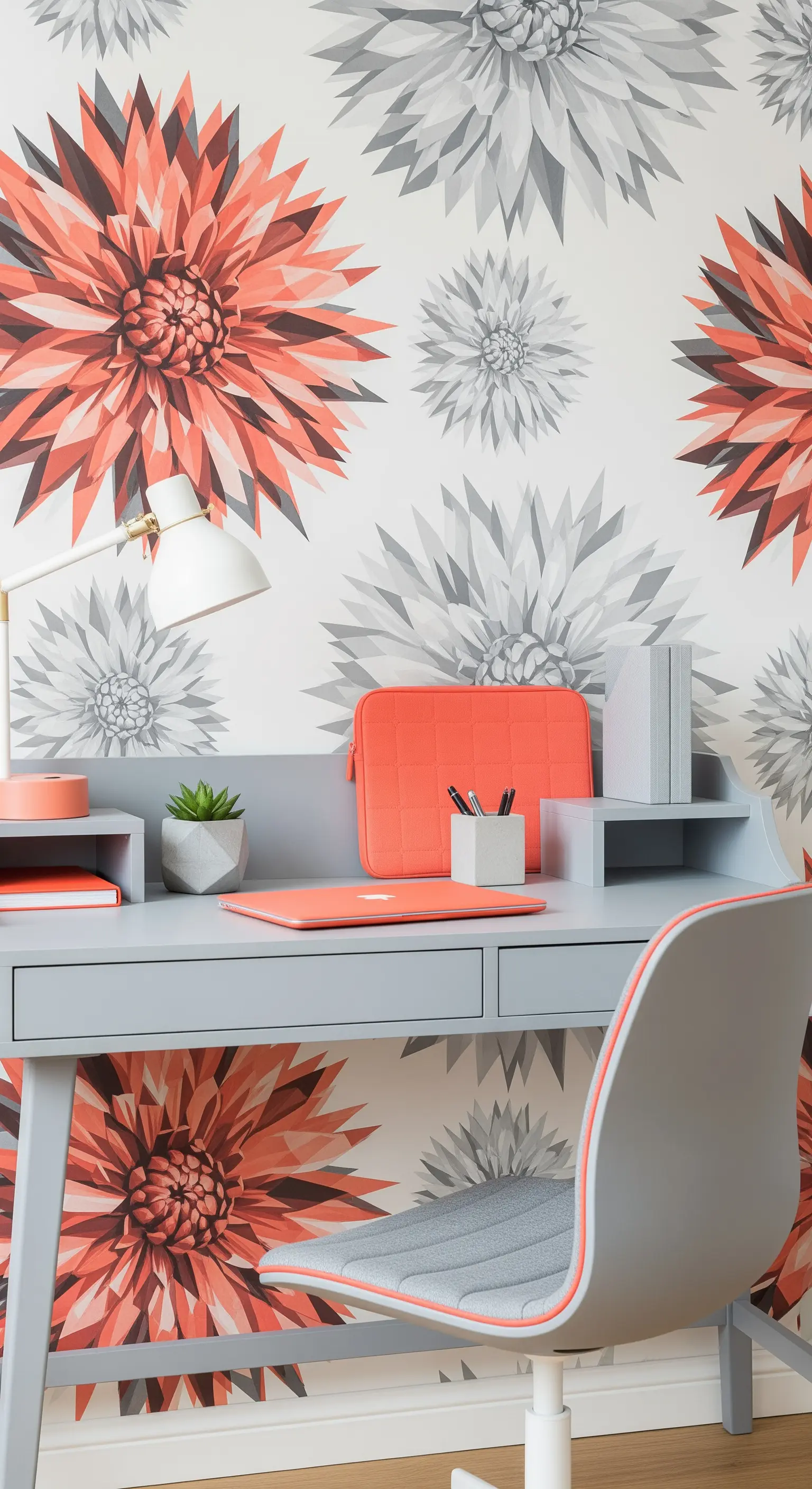 Scrivania grigia con sedia abbinata e accessori corallo davanti a una carta da parati con dalie.