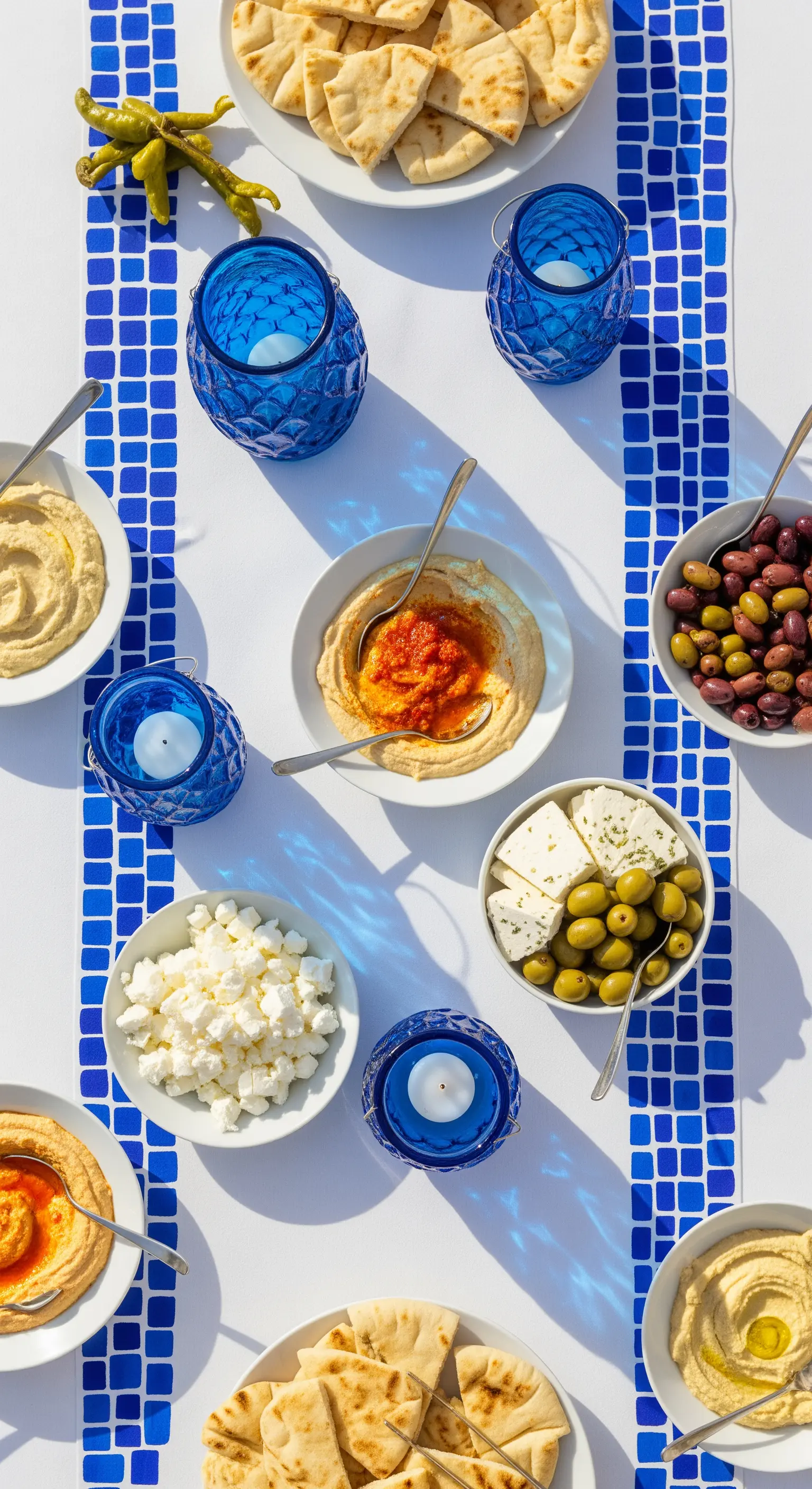 Runner bianco con motivo a mosaico blu stampato a mano, con portacandele blu.