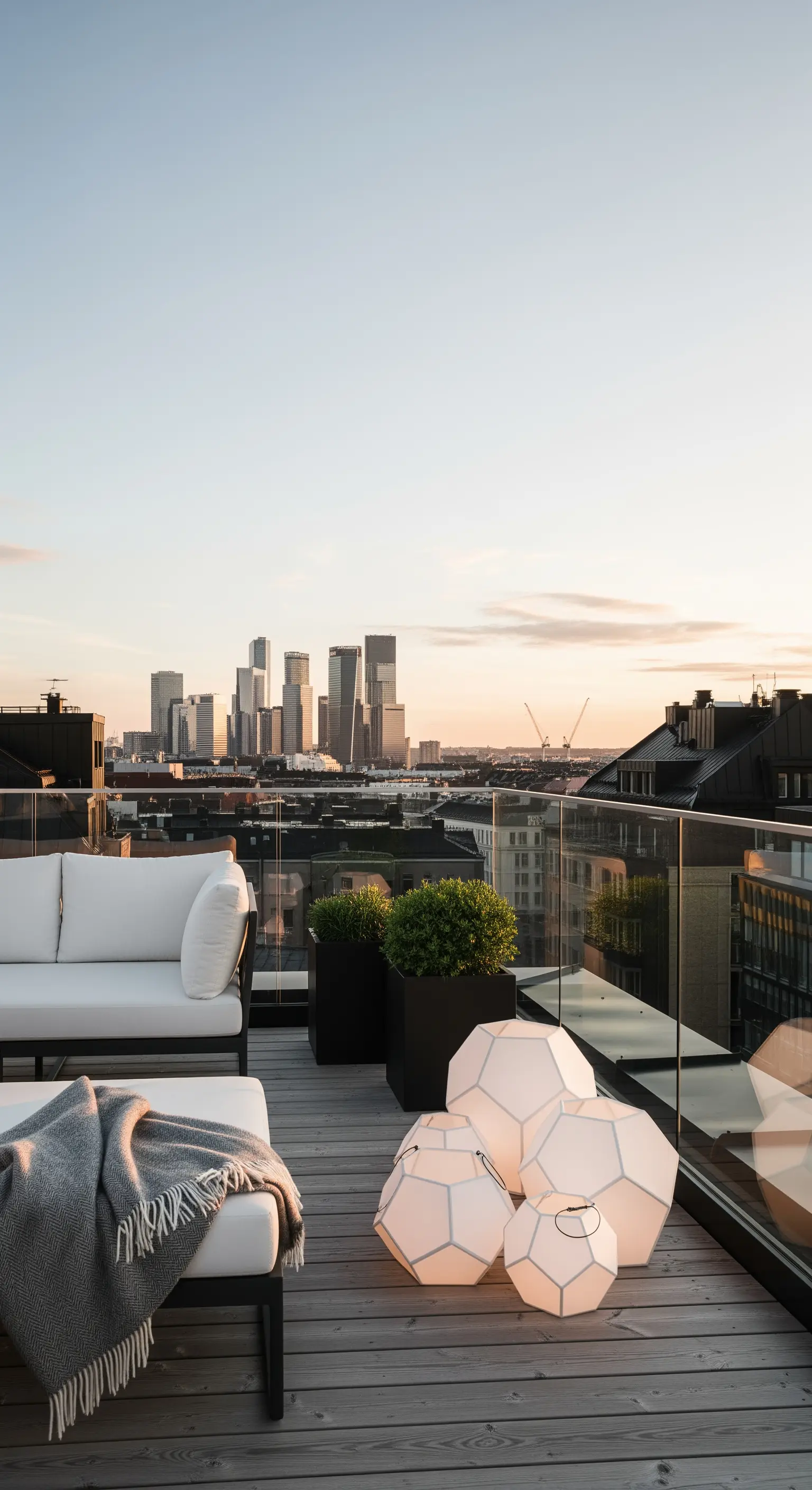 Terrazza panoramica con divano bianco e un set di lanterne geometriche di design.