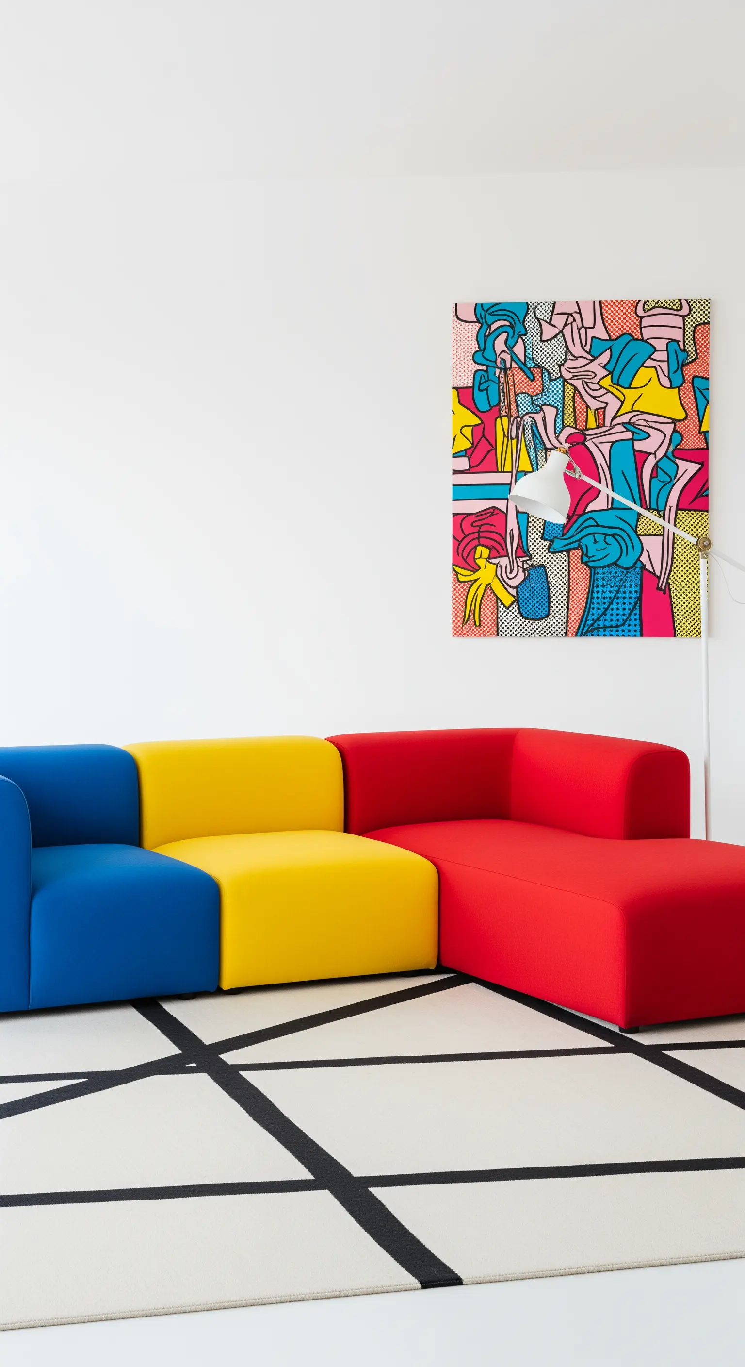 Soggiorno Pop Art con divano componibile nei colori primari e tappeto a griglia bianco e nero.