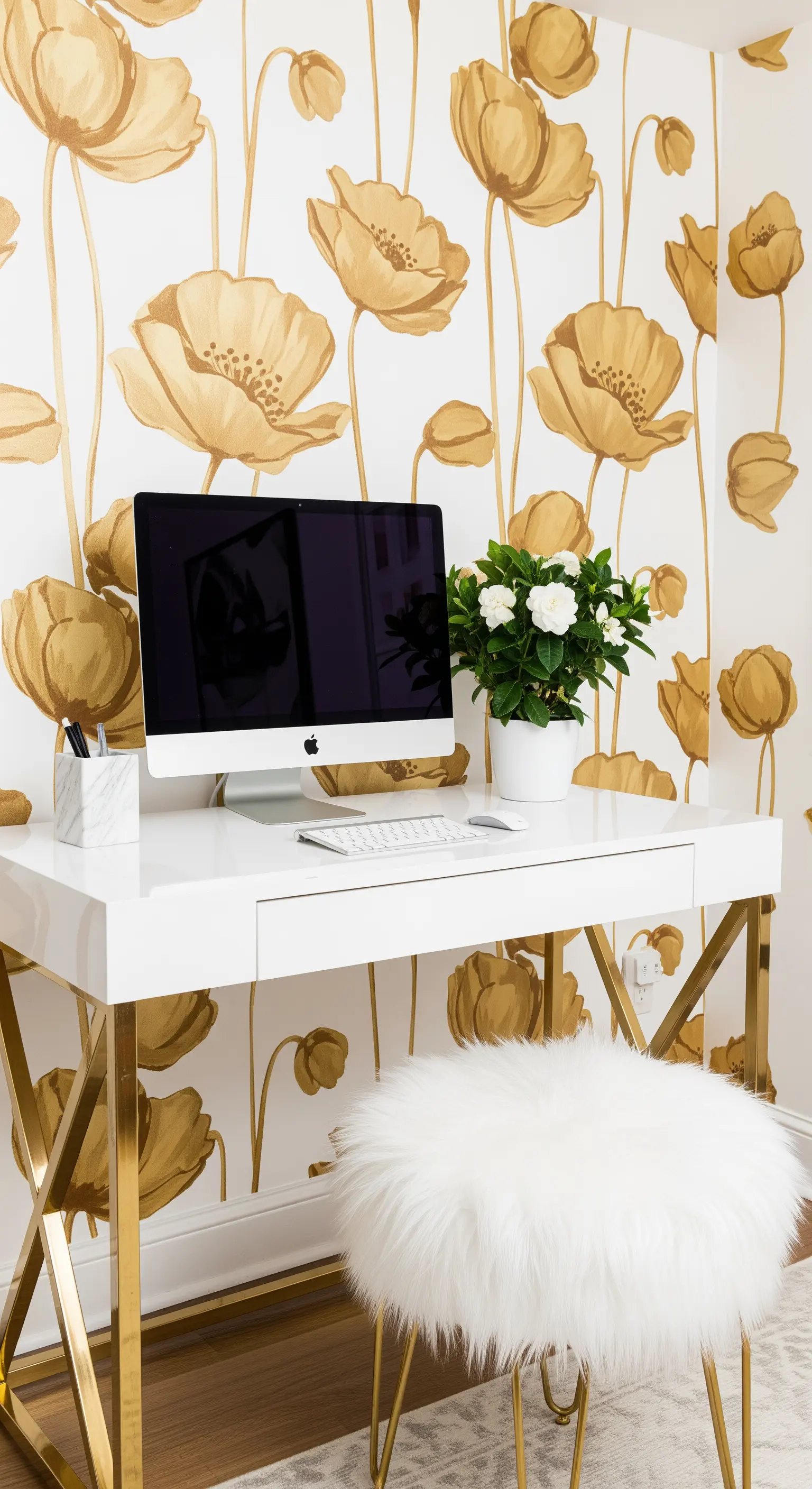 Scrivania bianca e oro con sgabello in pelliccia sintetica davanti a una parete con papaveri dorati.