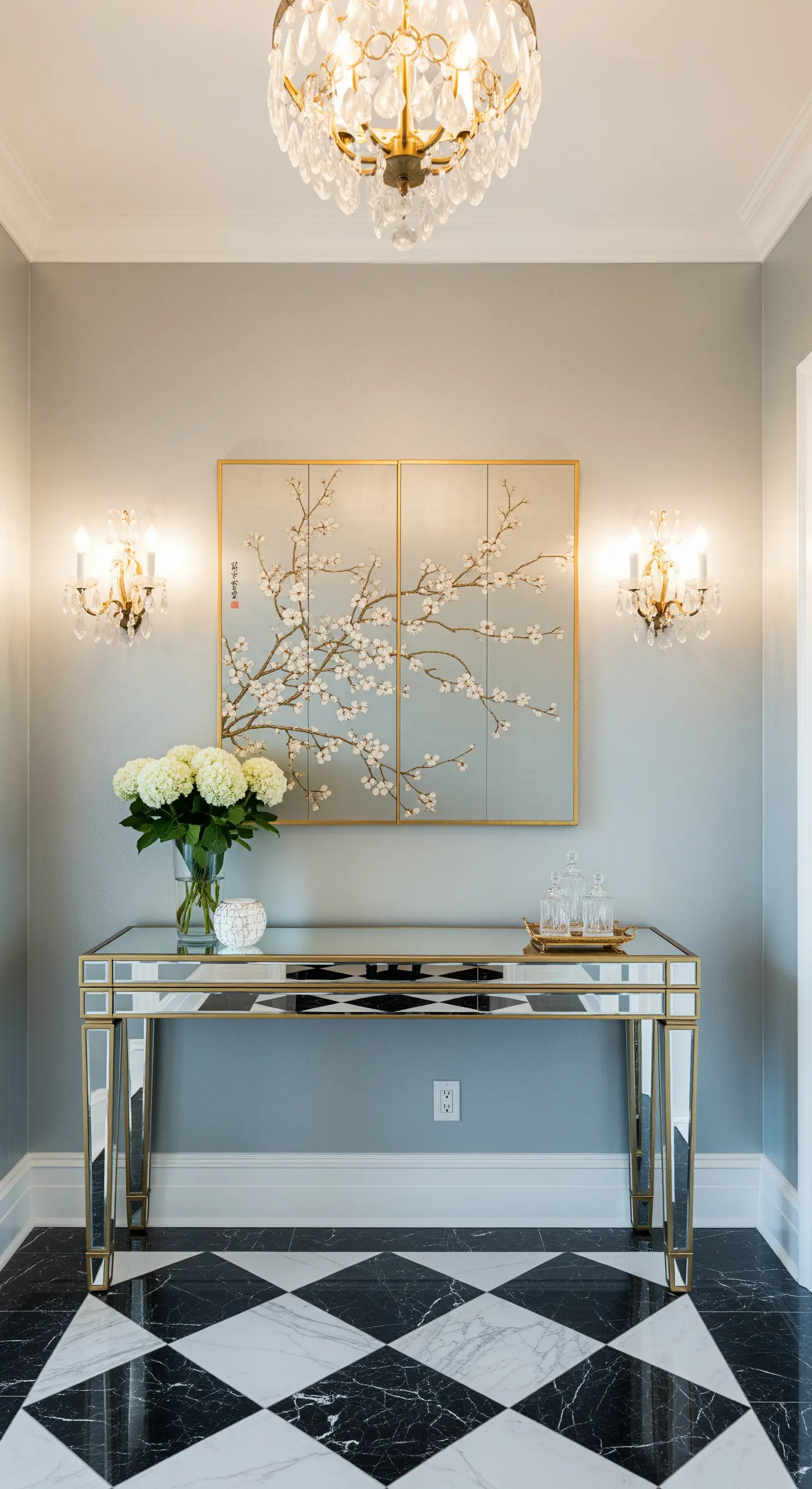 Ingresso elegante con consolle a specchio, pavimento a scacchi e parete grigia.