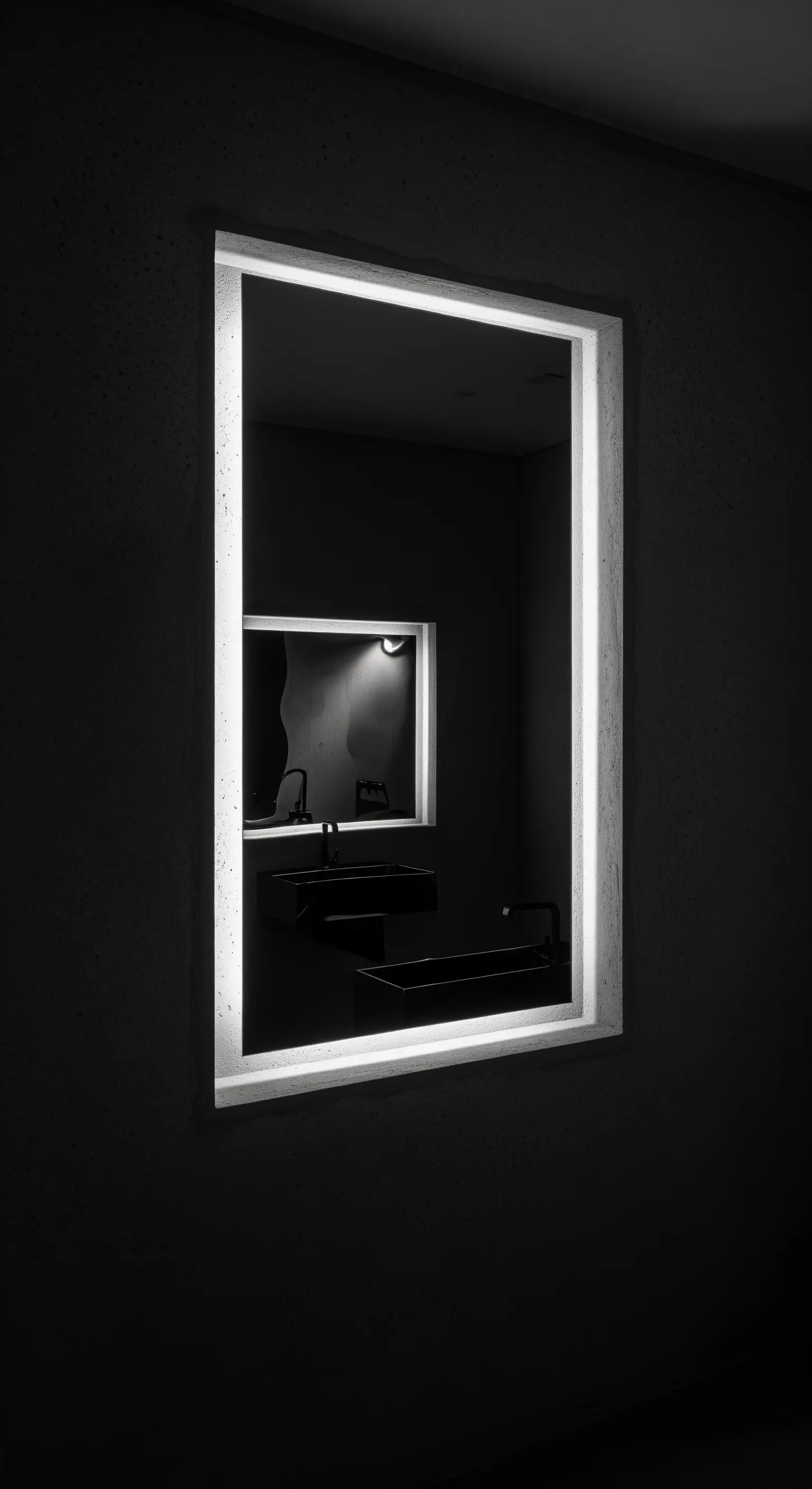 Specchio retroilluminato che si riflette in un altro specchio in un ambiente buio.