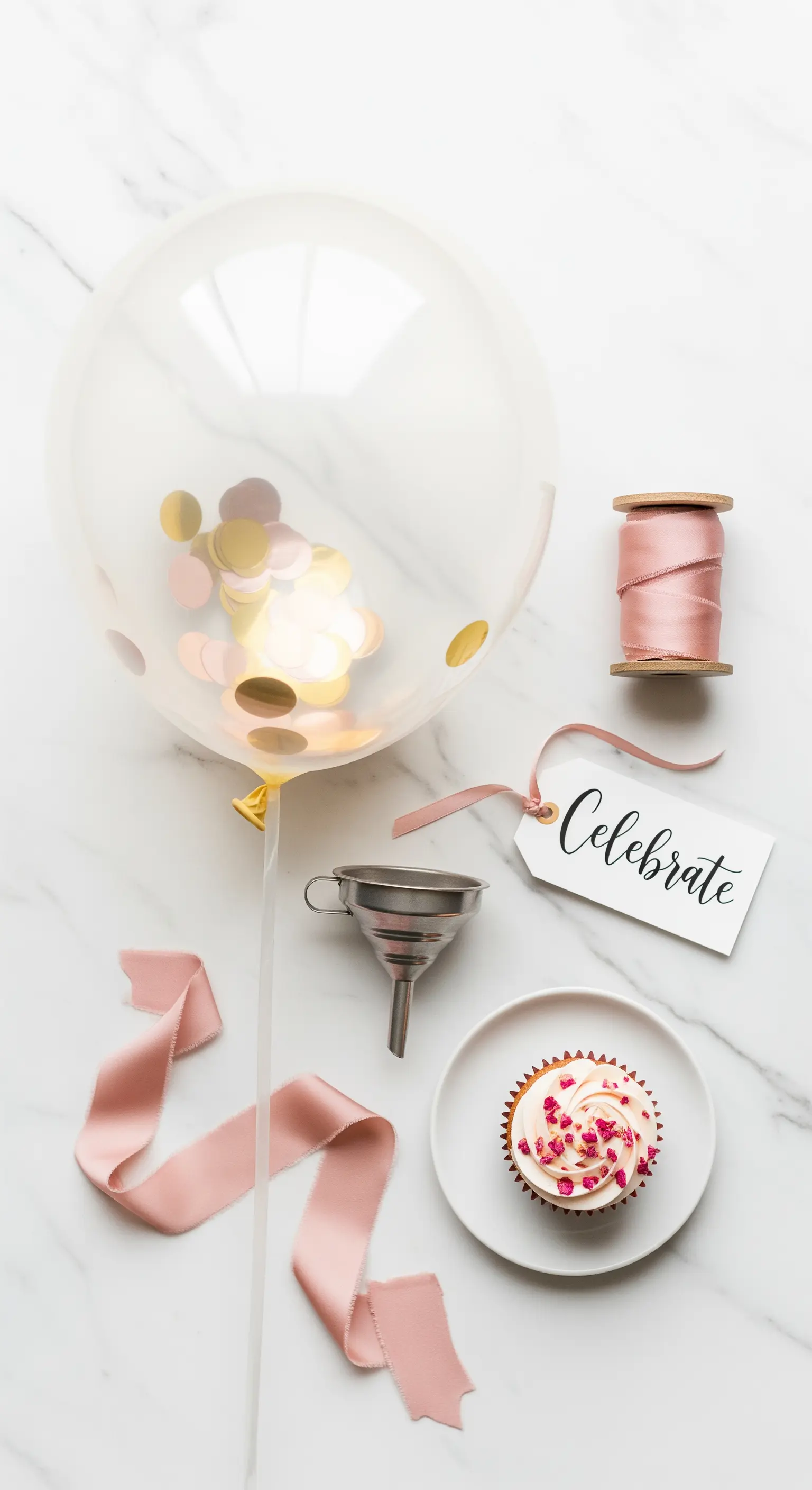 Palloncino trasparente con coriandoli oro e rosa, abbinato a un cupcake e a un nastro di raso.