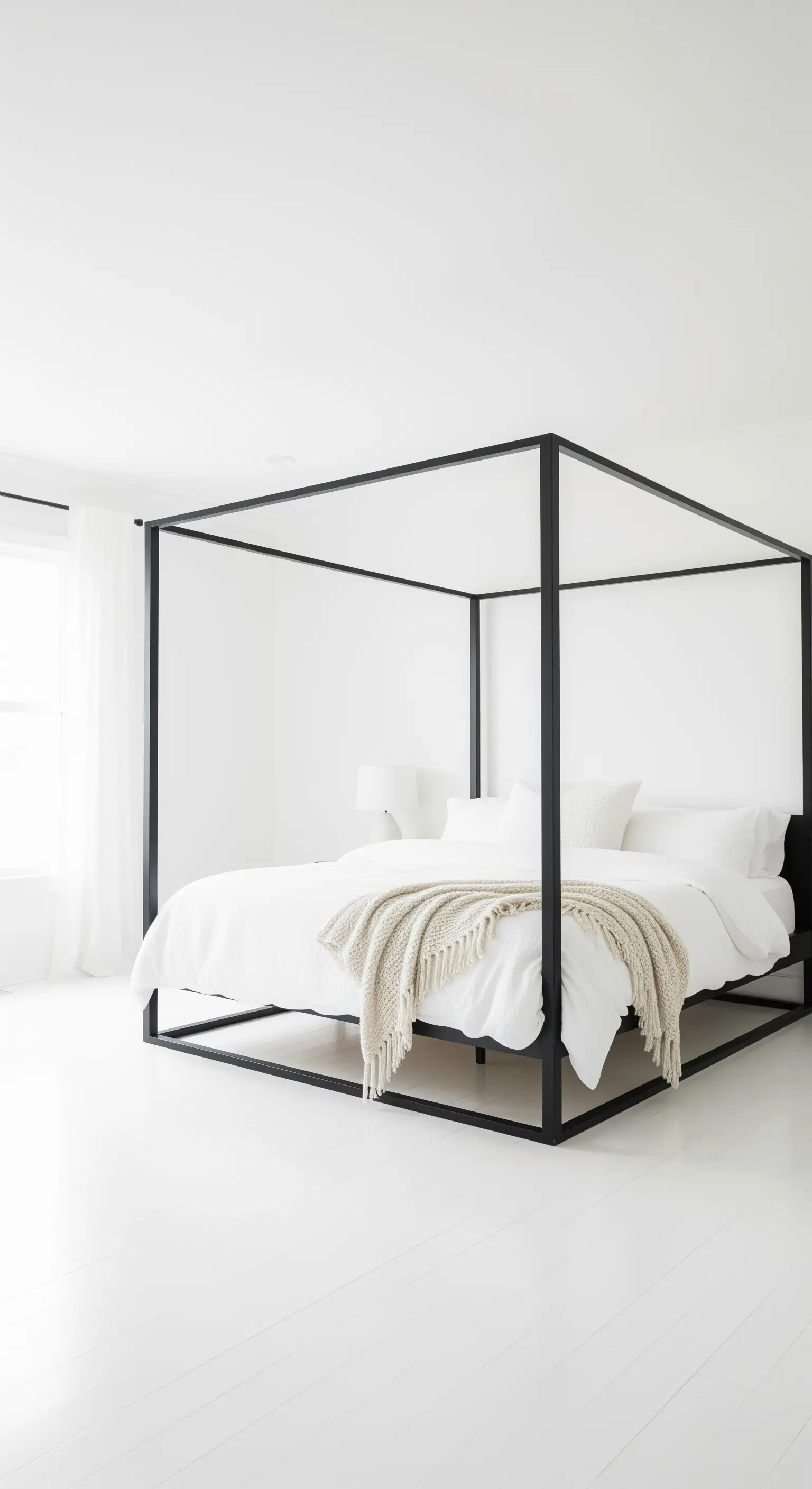 Letto a baldacchino nero in una camera da letto completamente bianca per un effetto ad alto contrasto.