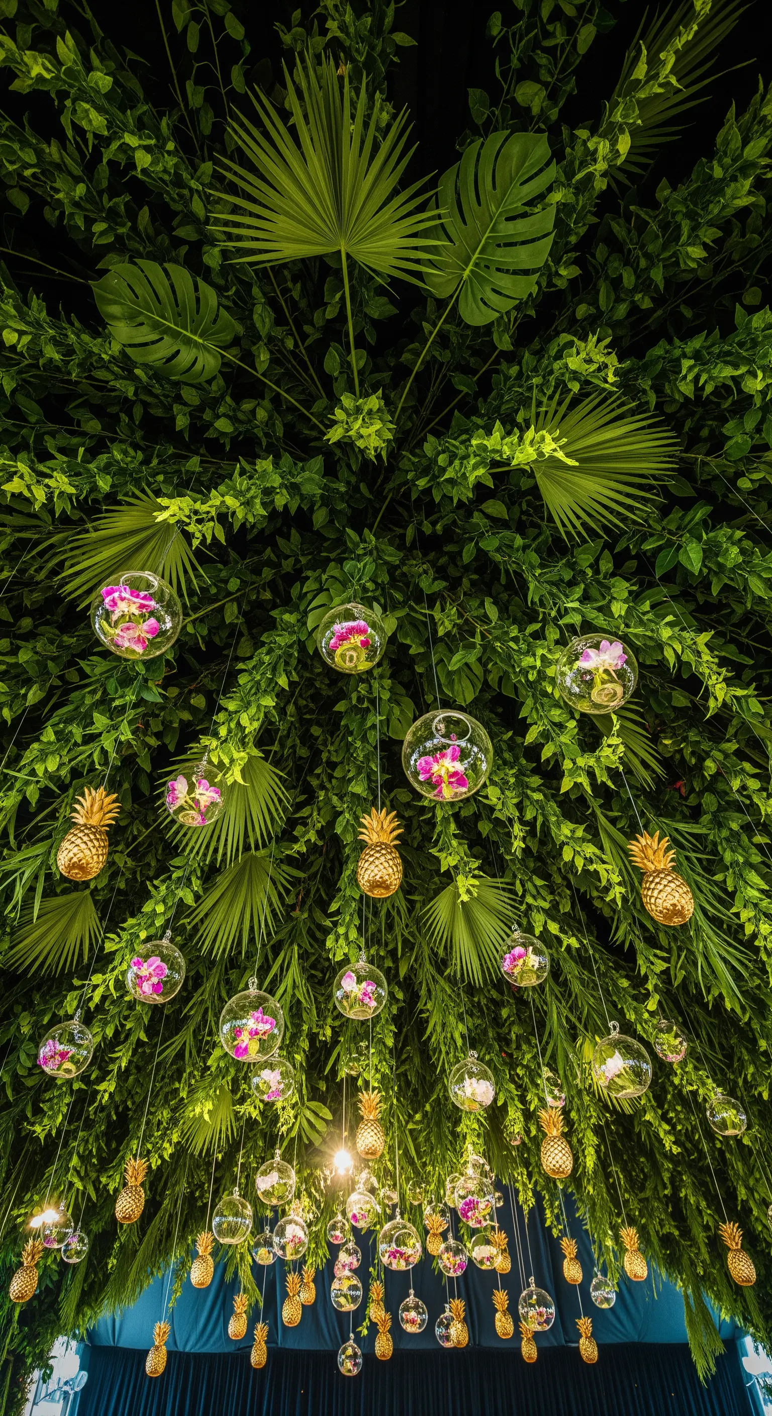 Soffitto decorato con una fitta vegetazione, sfere di vetro con orchidee e piccoli ananas dorati.