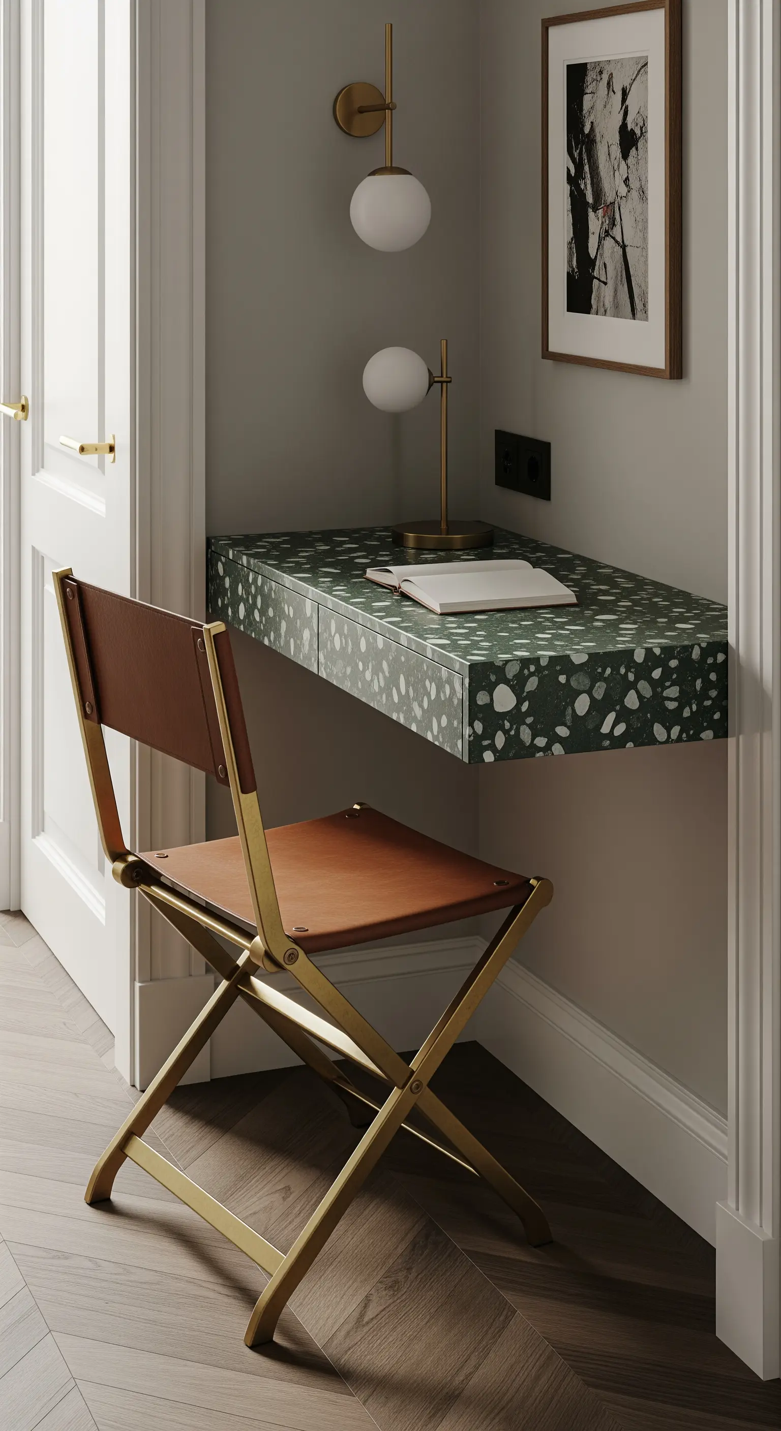 Scrivania sospesa in terrazzo verde e bianco in una piccola nicchia, con sedia pieghevole in ottone.
