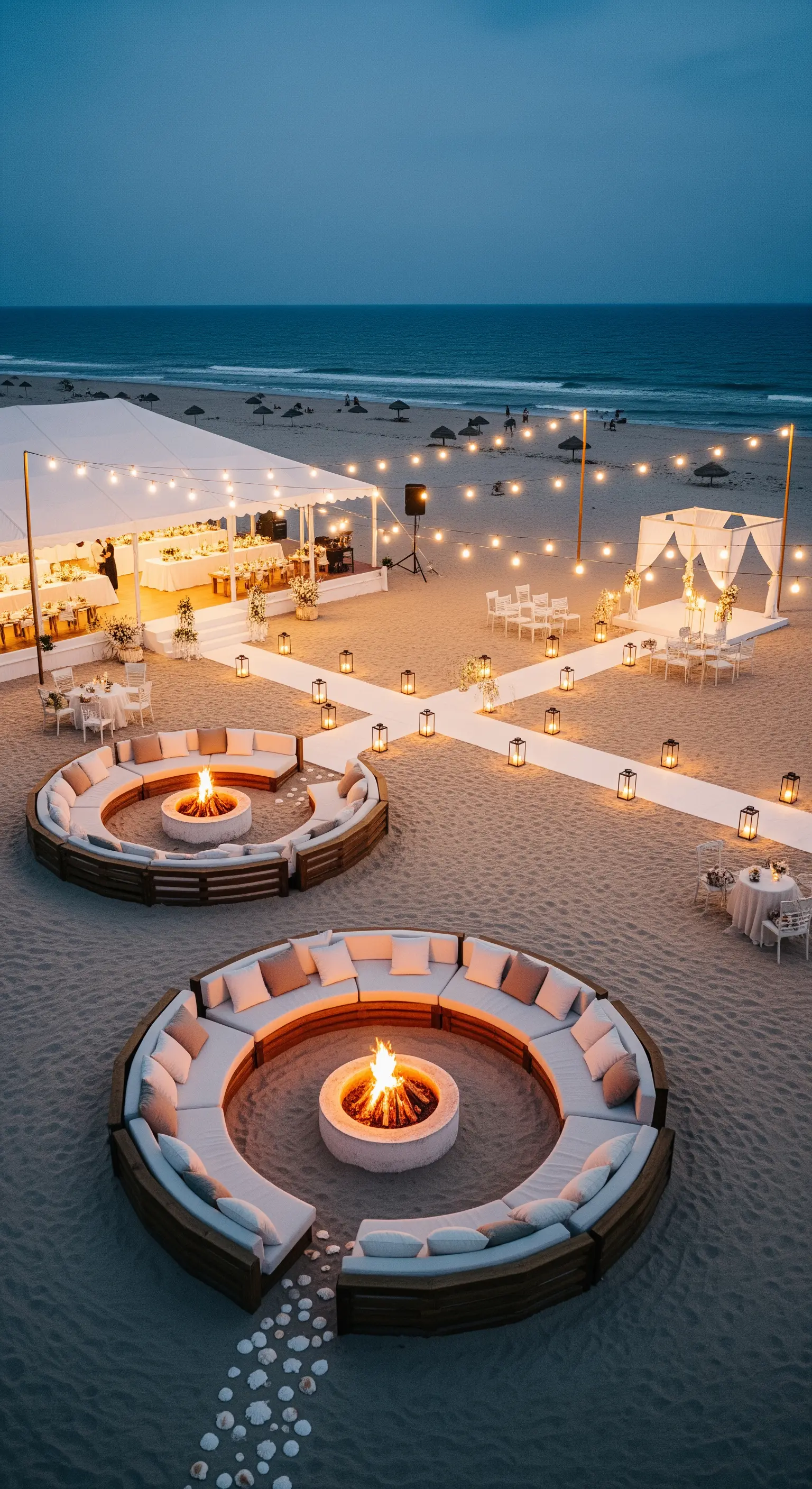 Grande festa serale sulla spiaggia con aree lounge circolari attorno a bracieri.