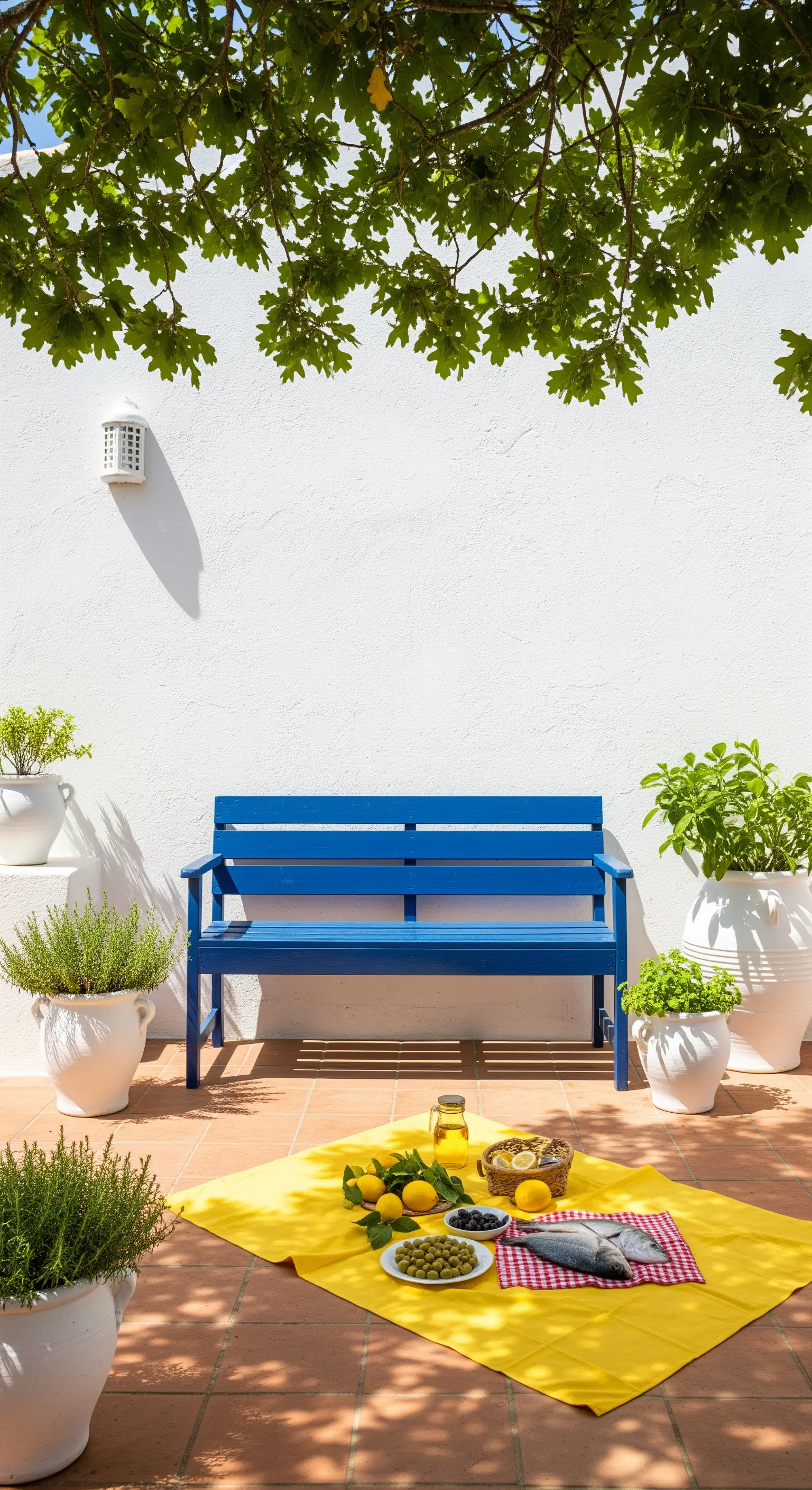 Panchina blu cobalto su un patio bianco, con una tovaglia gialla per un picnic estivo.
