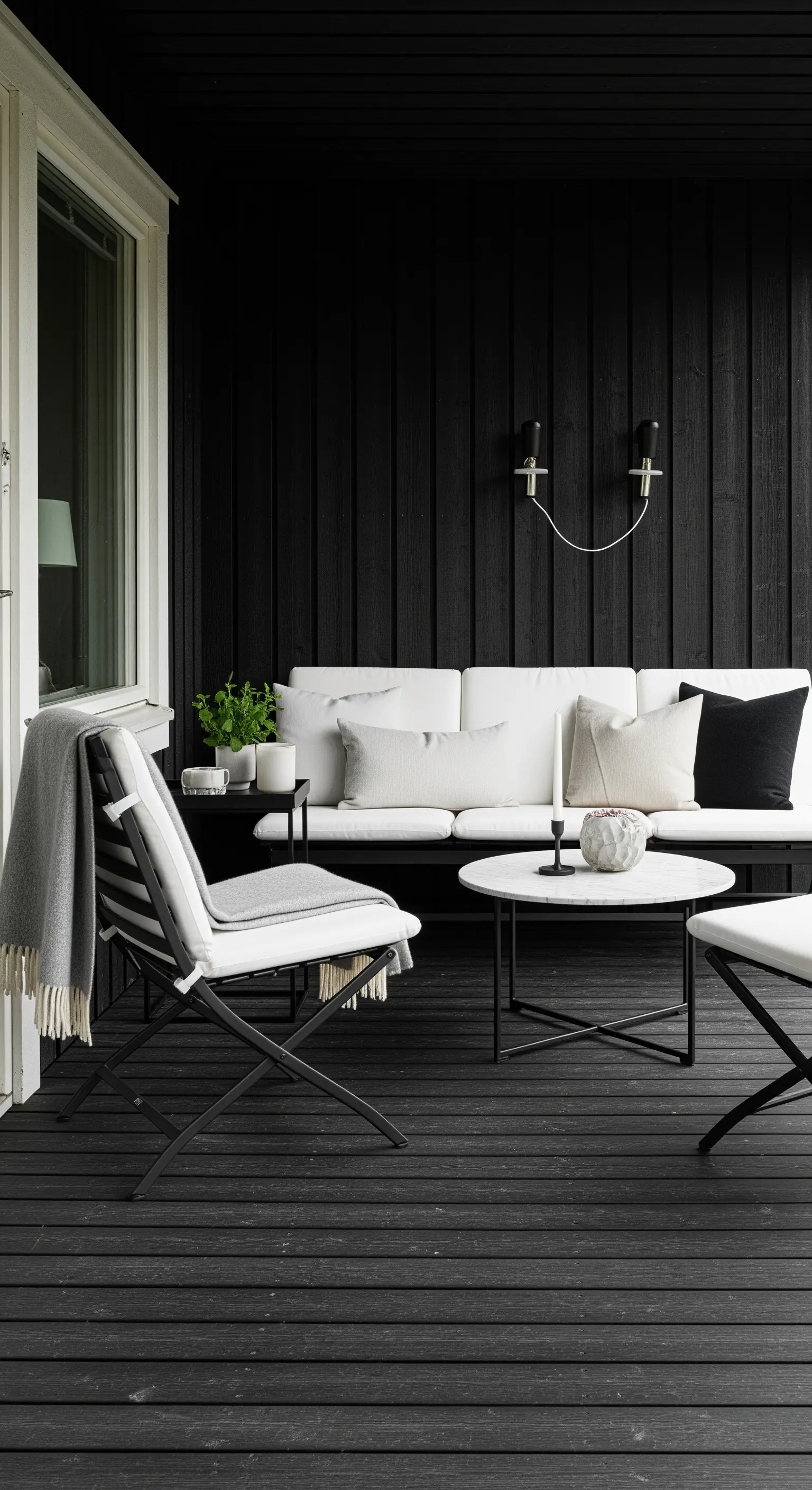 Portico moderno con parete nera, pavimento nero e arredi in bianco e nero a contrasto.