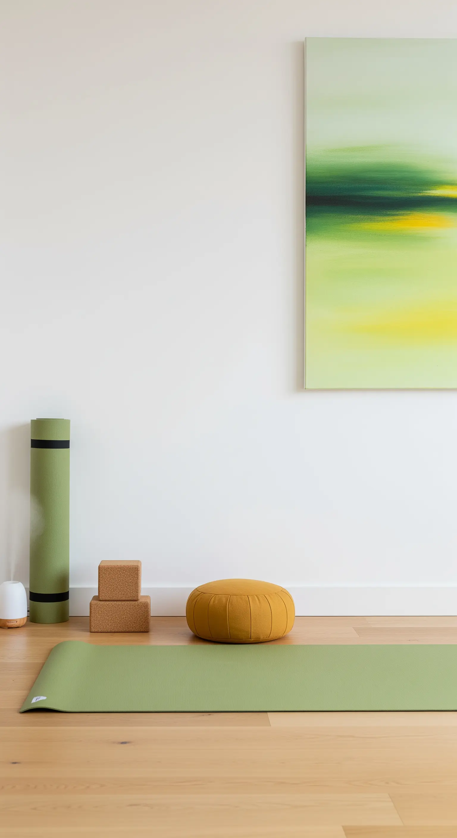 Angolo yoga minimalista con tappetino verde, cuscino senape e un quadro astratto.