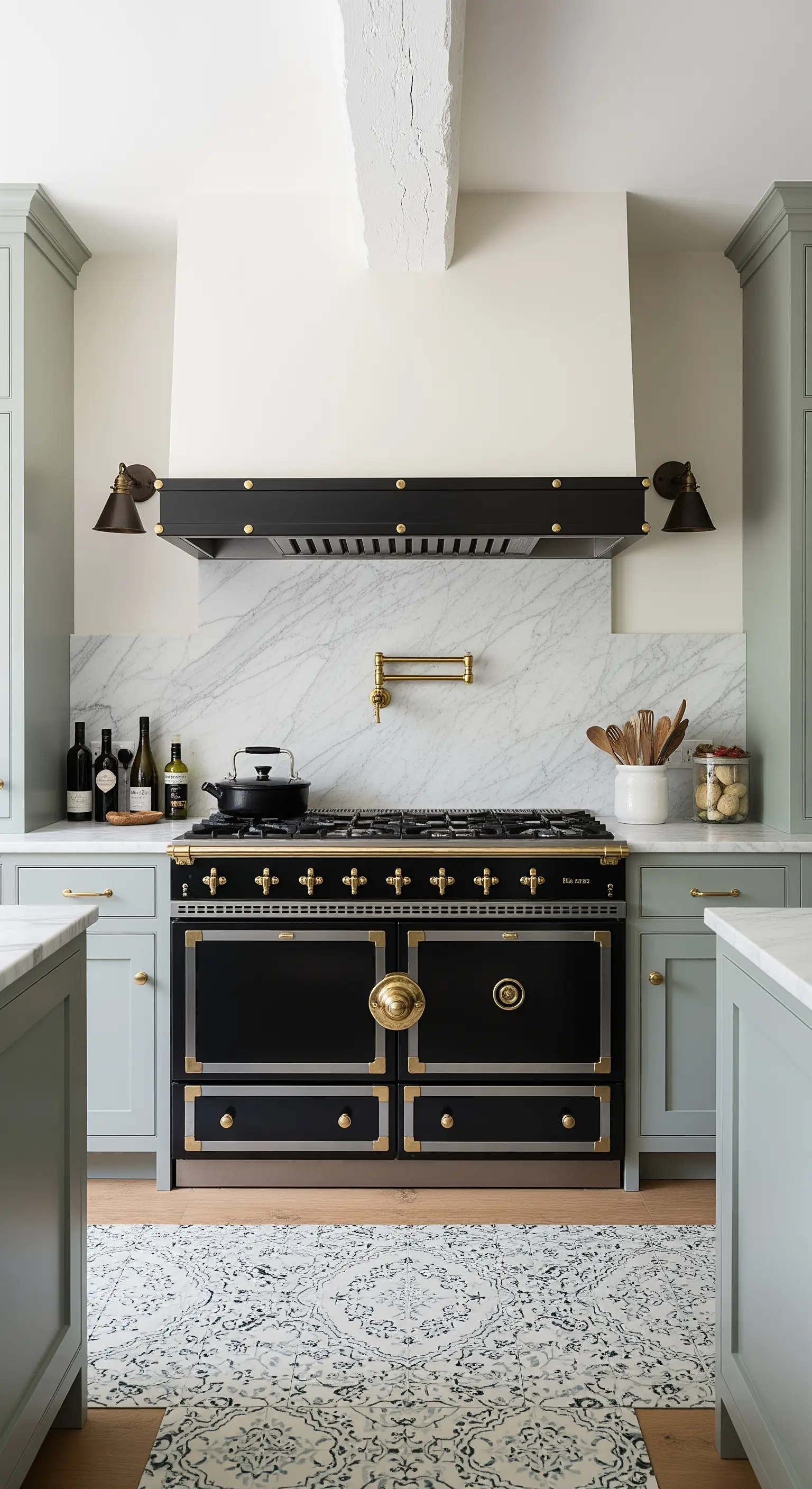 Cucina professionale nera e ottone, incorniciata da mobili color salvia e paraschizzi in marmo.