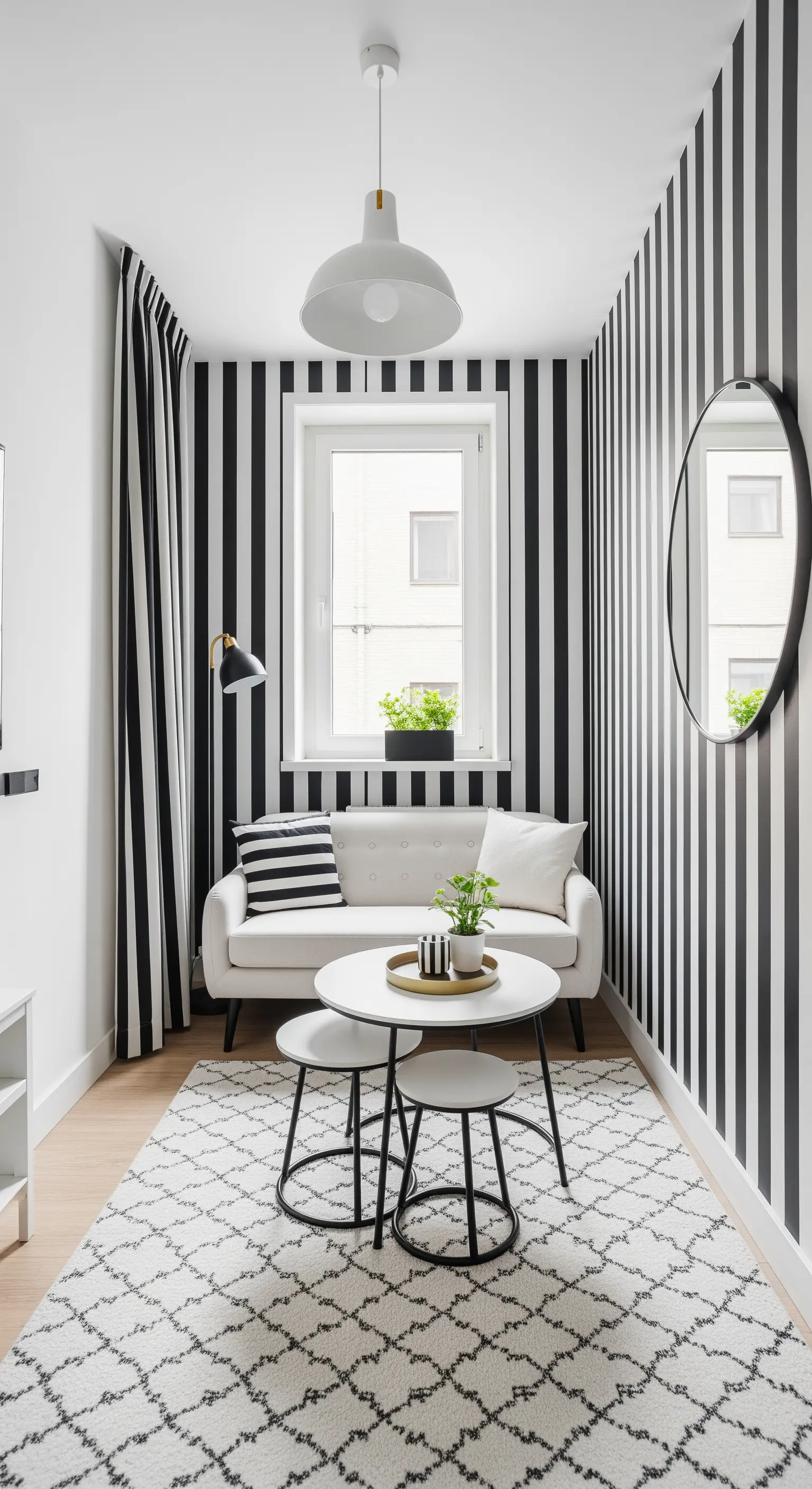 Piccolo salotto con pareti e tende a righe verticali bianche e nere.