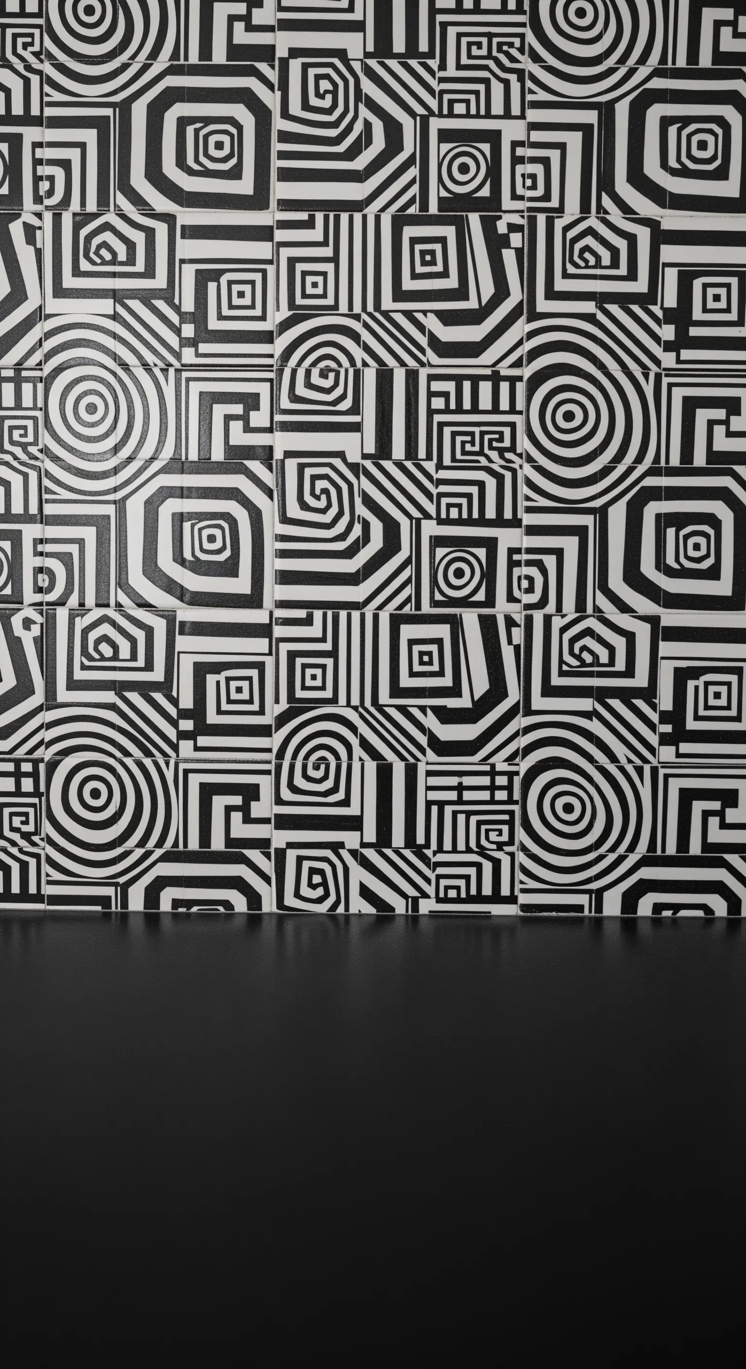 Parete di piastrelle con un complesso motivo geometrico labirintico in bianco e nero.