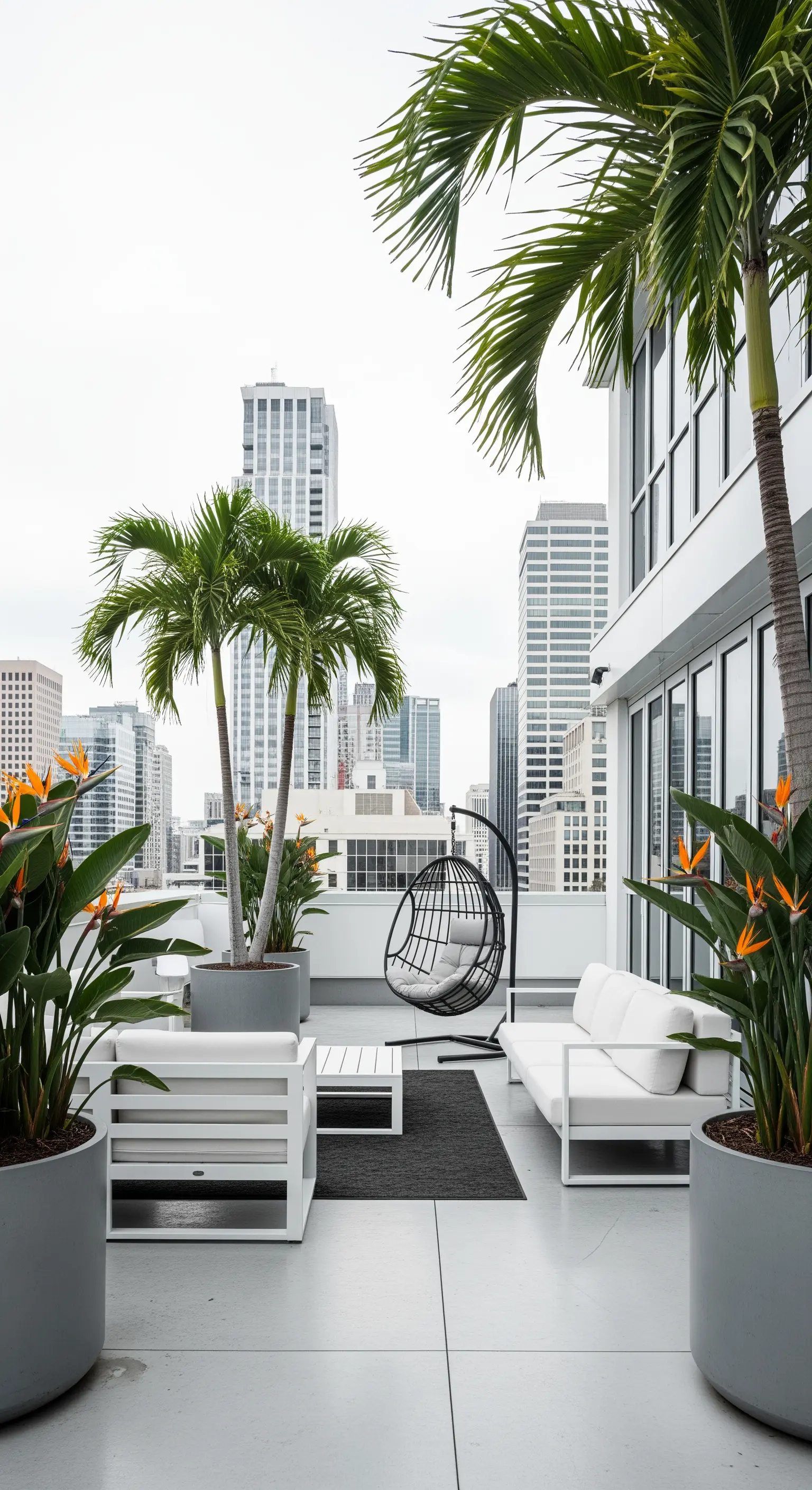 Terrazza urbana minimalista con divani bianchi, poltrona sospesa e grandi palme in vaso.