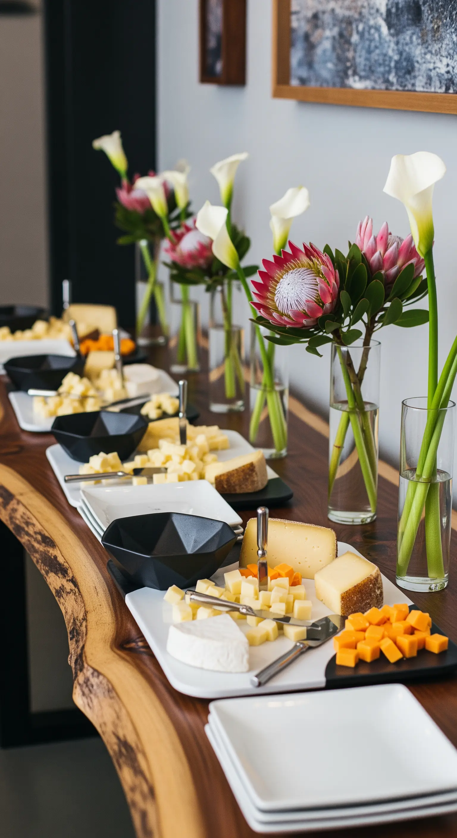 Buffet di formaggi allestito su un tavolo in legno con bordo irregolare.