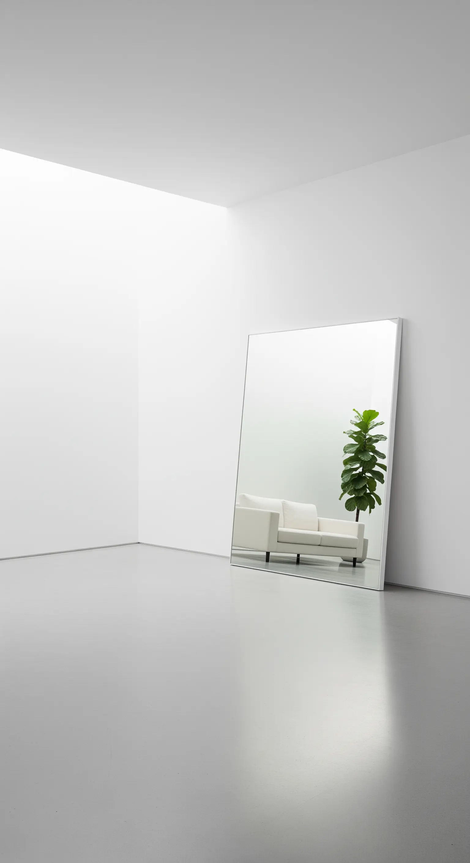 Grande specchio senza cornice appoggiato al muro in un angolo di una stanza bianca e minimale.