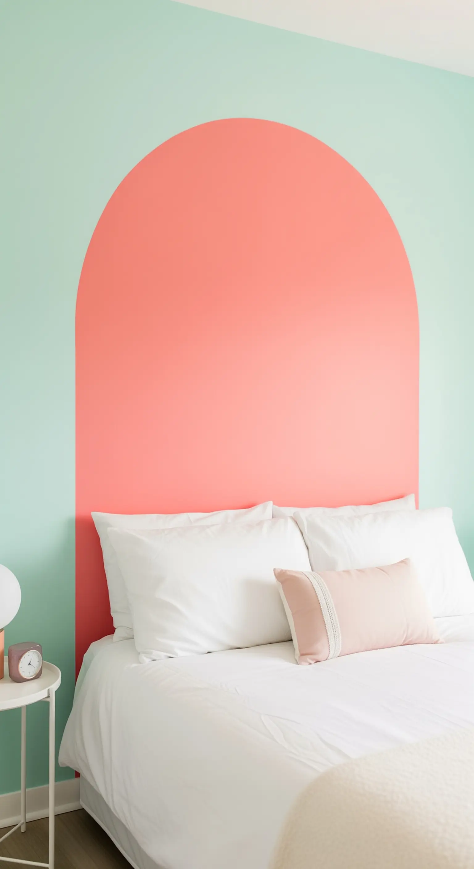Testiera a forma di arco color corallo dipinta su una parete verde menta.
