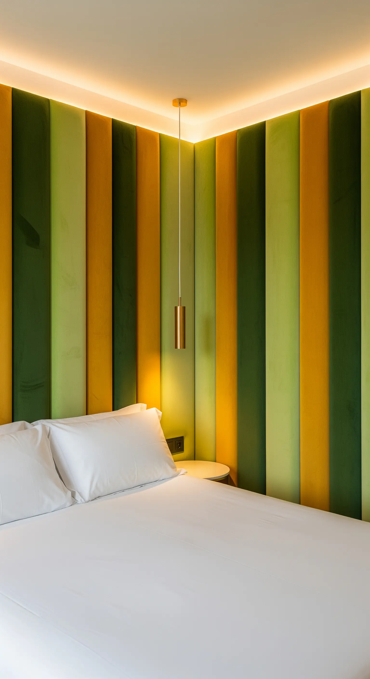 Parete dietro il letto rivestita con pannelli imbottiti verticali in velluto verde e giallo.