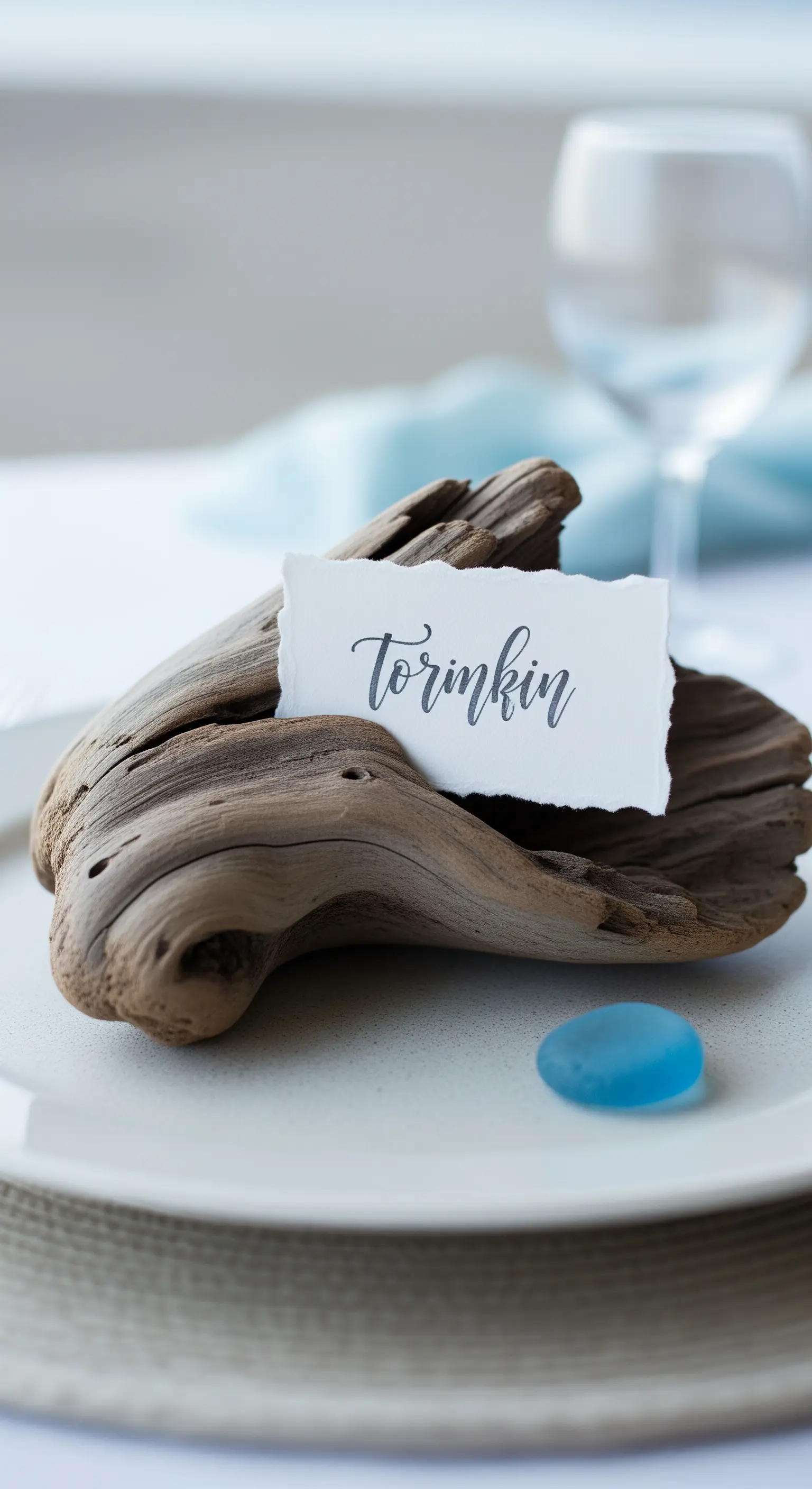 Pezzo di legno di mare che sorregge un biglietto con nome su un piatto.