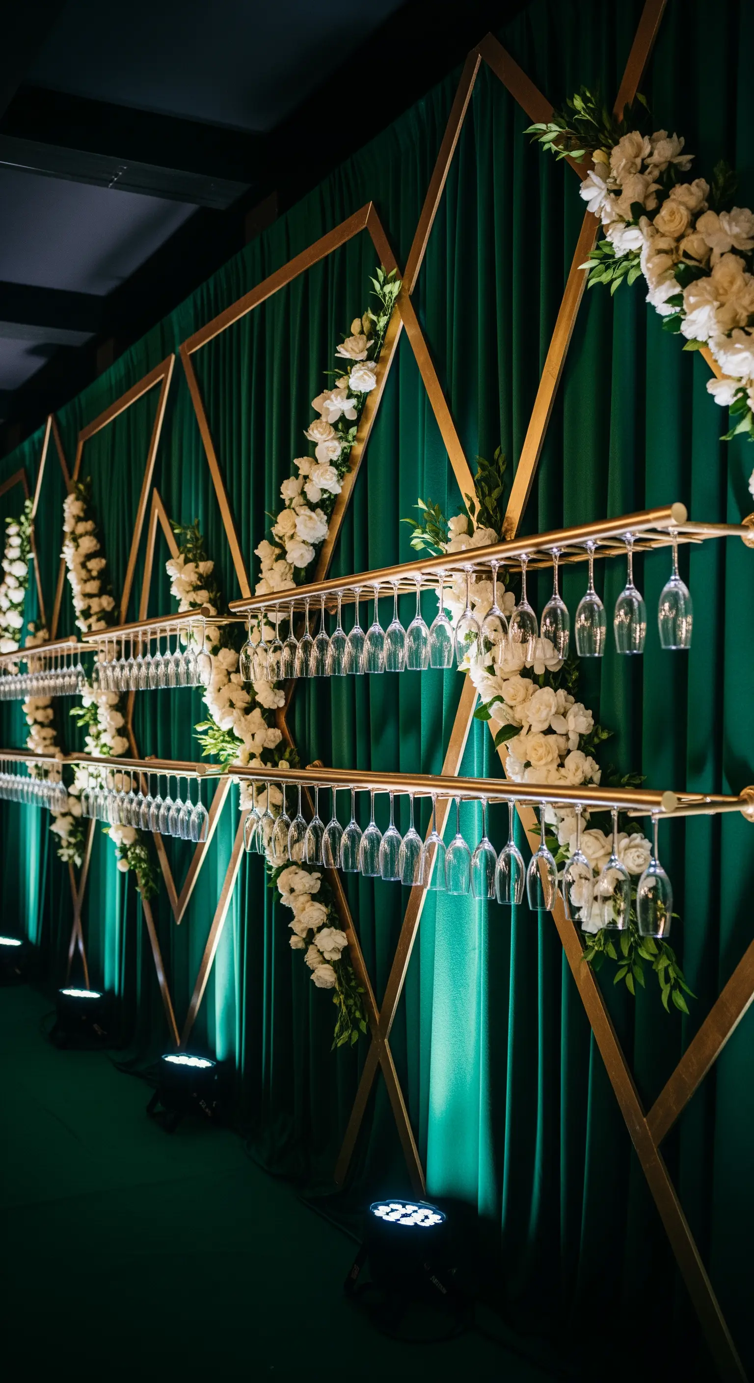 Backdrop di tende verde smeraldo con struttura geometrica dorata e rose bianche.