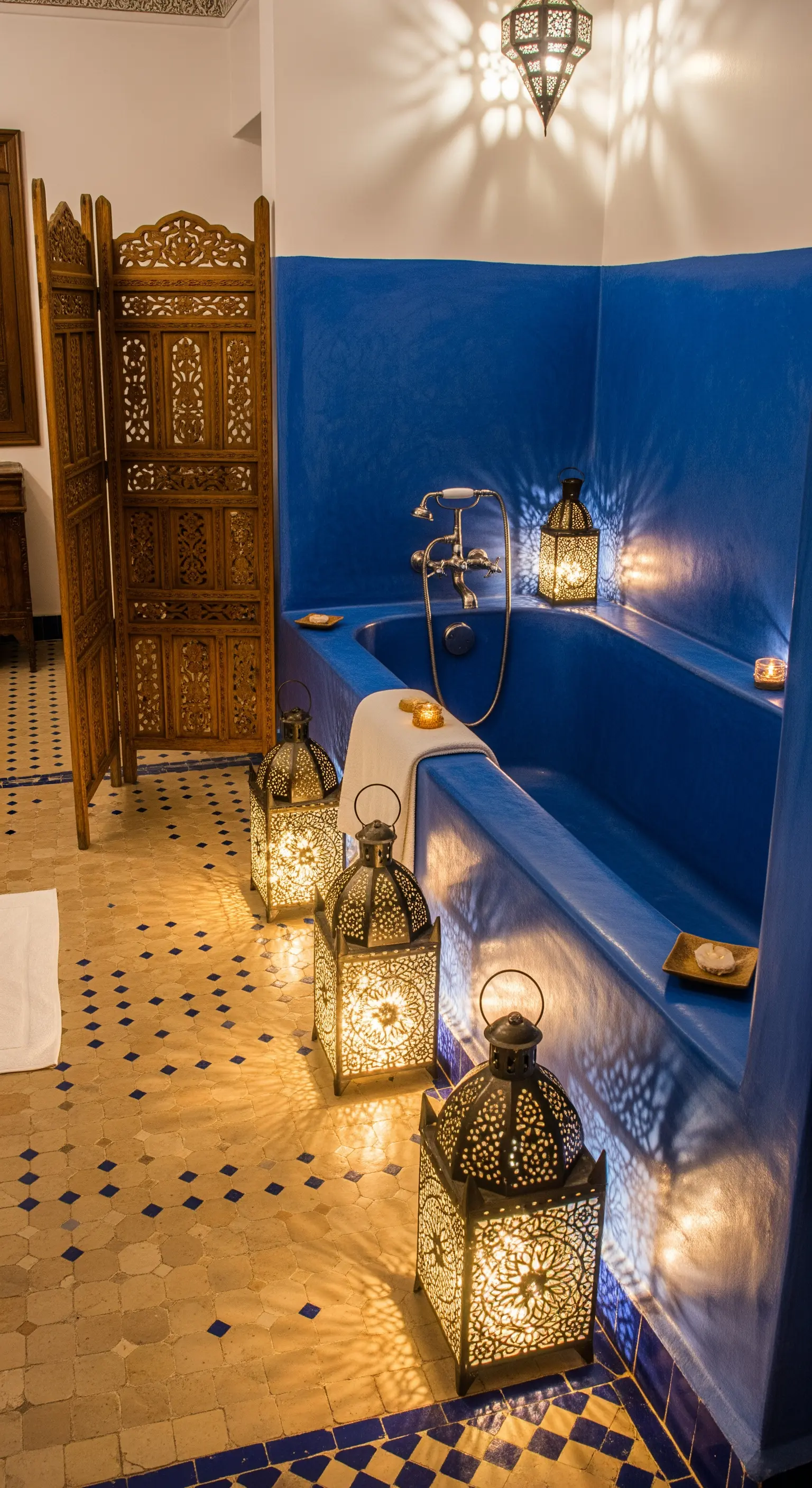 Bagno marocchino blu con lanterne metalliche intagliate che proiettano luci e ombre.